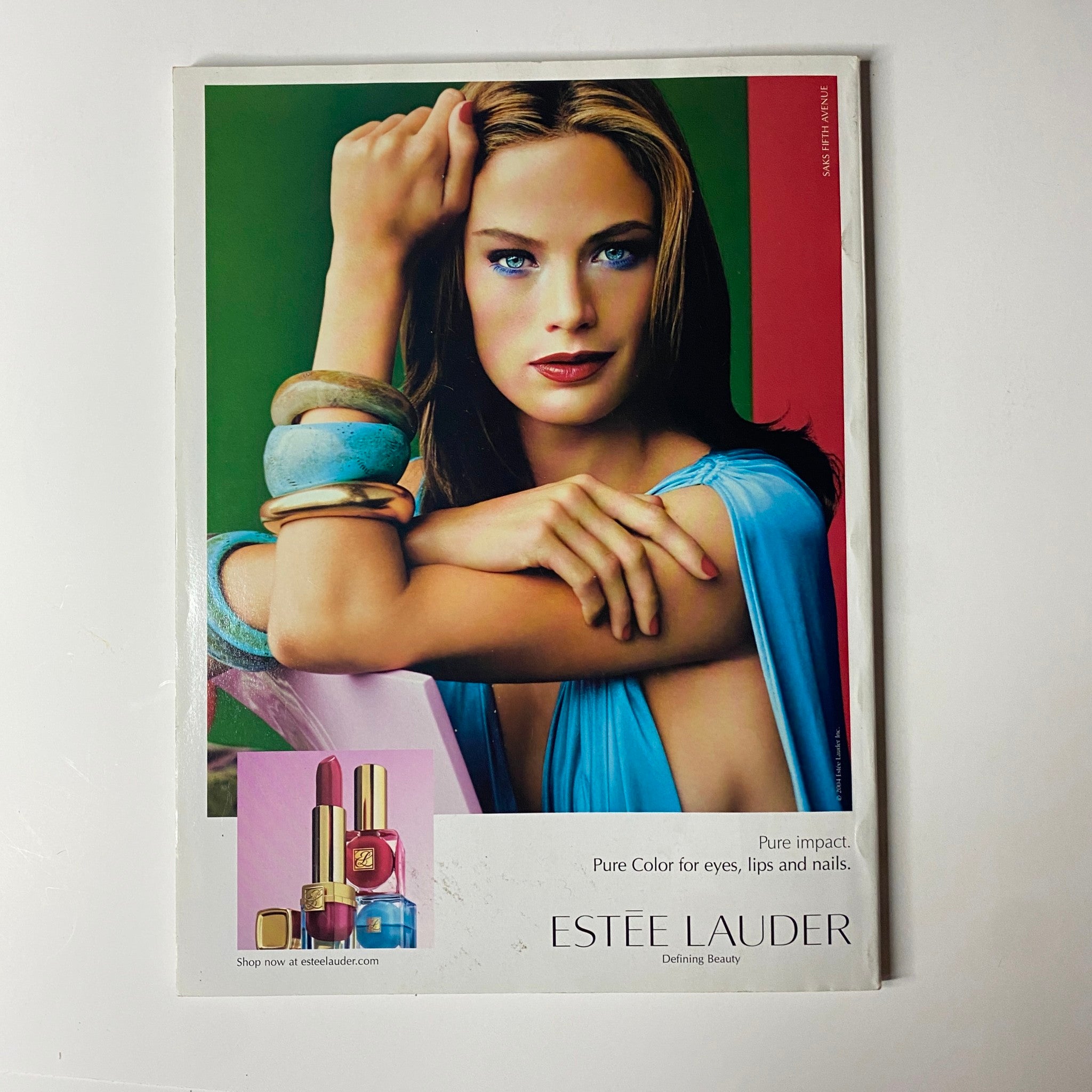 Advertisement for Estée Lauder in Vogue Magazine July 2004, showcasing makeup products and a model promoting beauty and skincare.