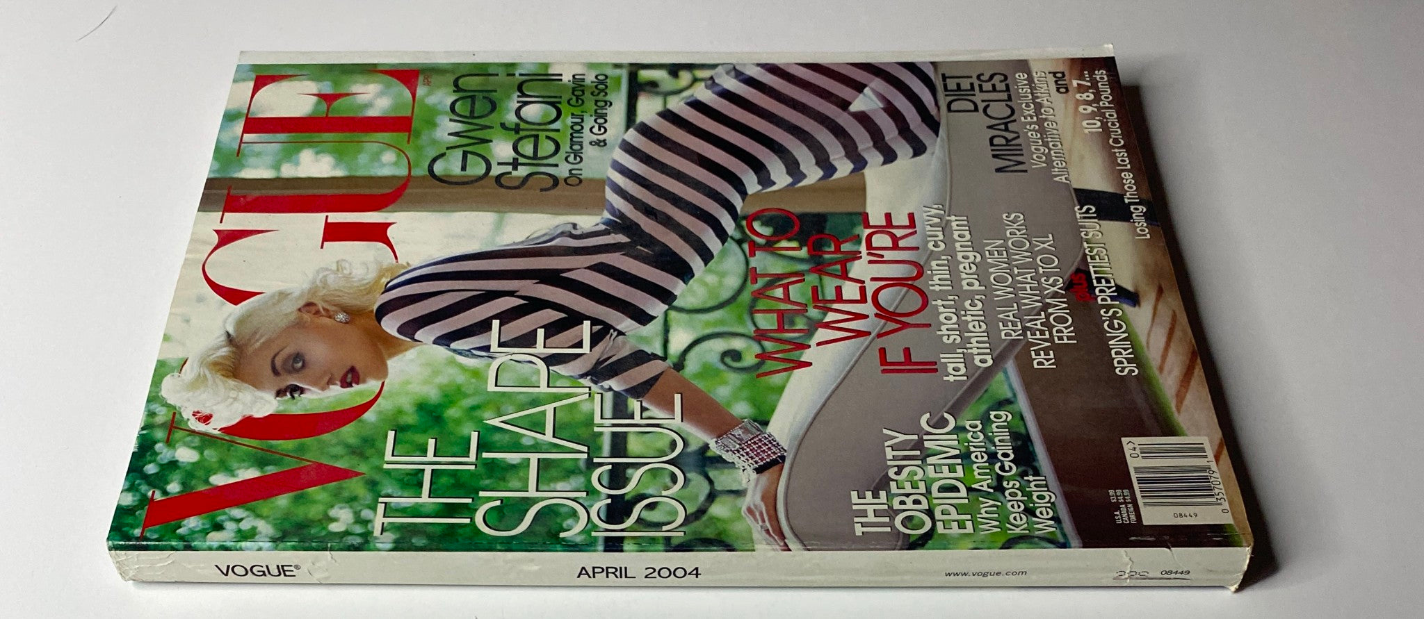 Side view of the Vogue Magazine April 2004 with Gwen Stefani on the cover, presenting her bold striped gown. The magazine emphasizes fashion tips and features on lifestyles and body shapes.