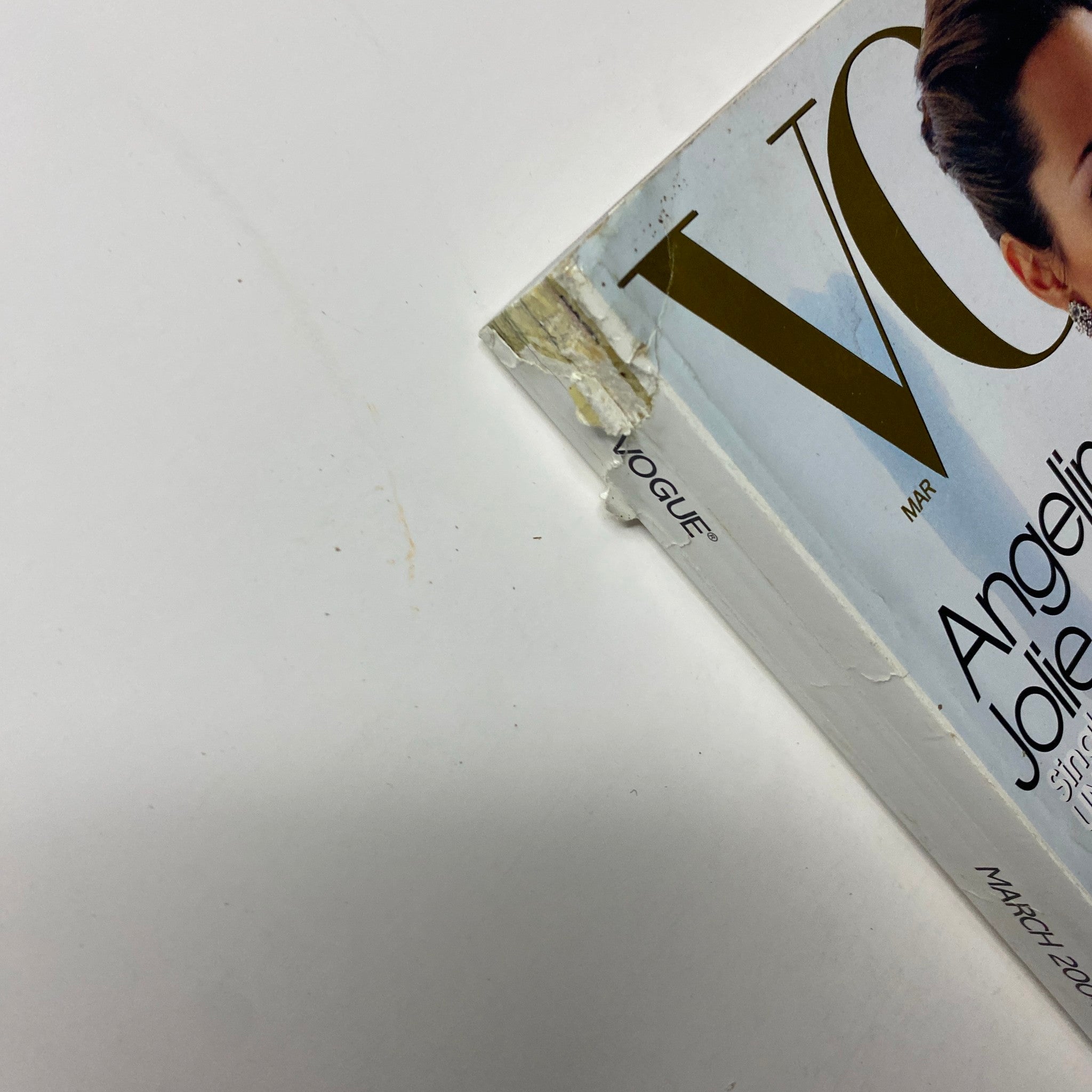 Close-up of the side of the March 2004 Vogue Magazine featuring Angelina Jolie; details include wear indicating its age while showcasing her iconic cover.
