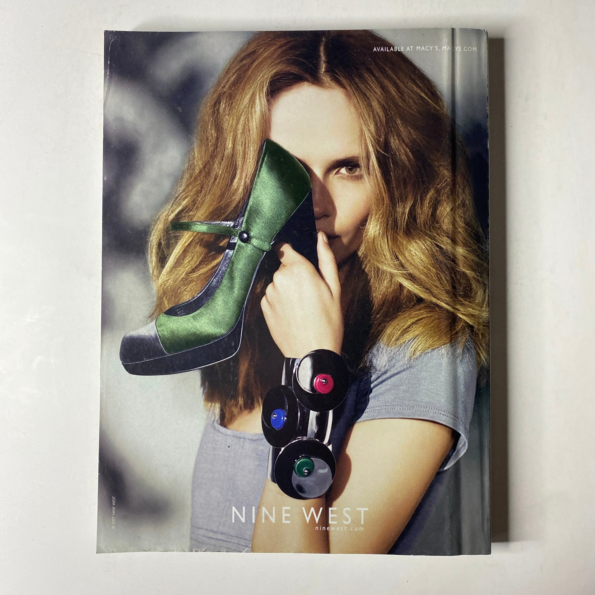 Vogue Magazine October 2007 Charlize Theron Cover featuring a striking advertisement for Nine West, highlighting a high-fashion model holding a vibrant green high-heeled shoe, illustrating modern accessories in women's fashion.