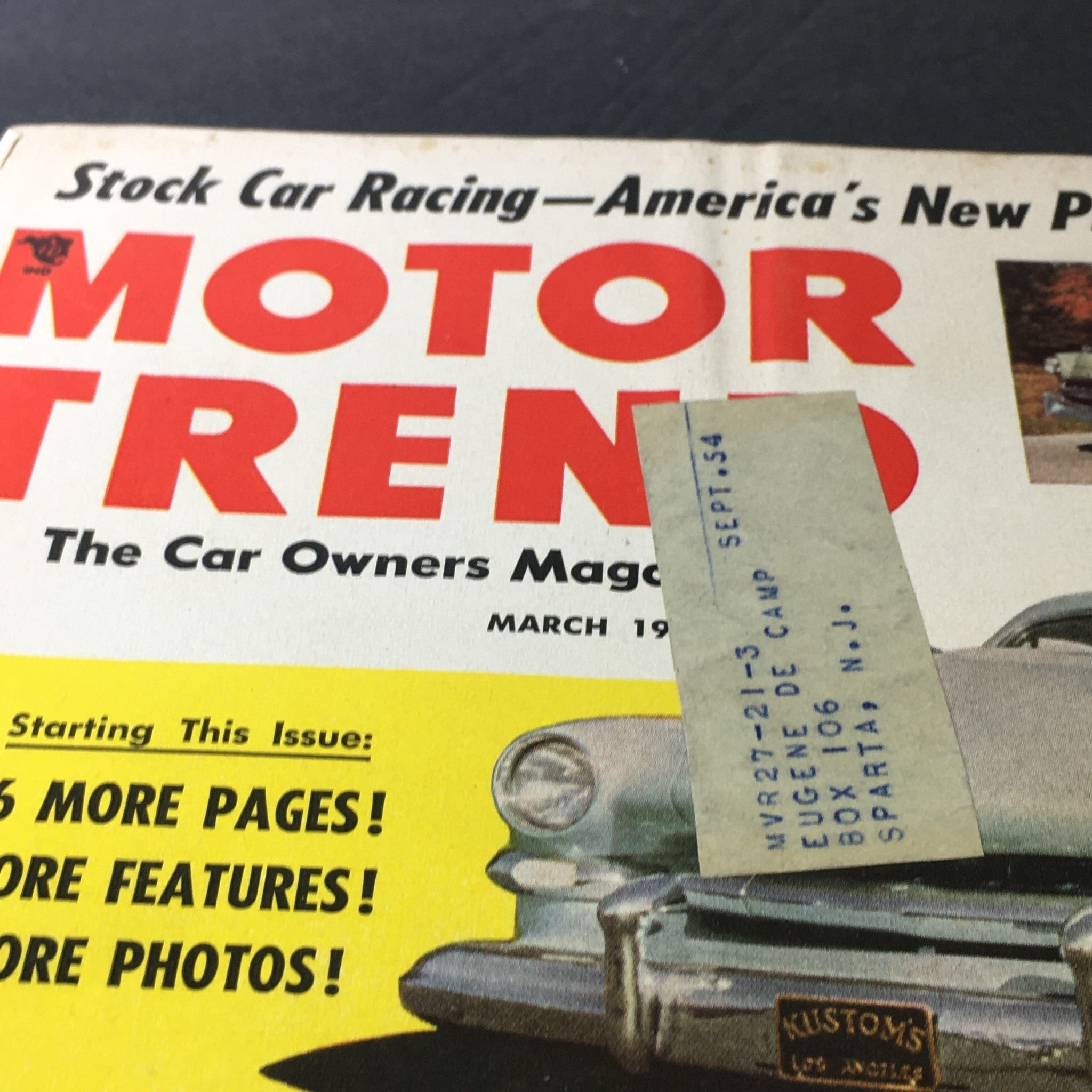 Close-up of the cover of VTG Motor Trend Magazine March 1953, highlighting the magazine title and a label on the front, showcasing its vintage appeal and historical significance in automotive culture.