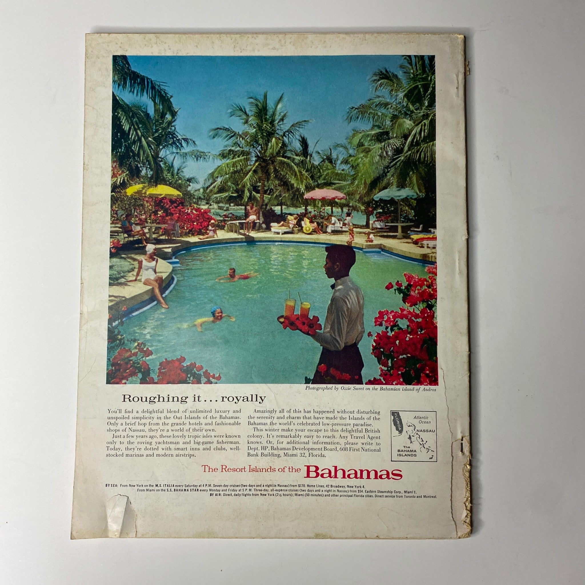 Advertisement for the Bahamas in Vogue Magazine – February 15, 1962, featuring lush tropical imagery and a swimming pool setting, promoting a vacation lifestyle.