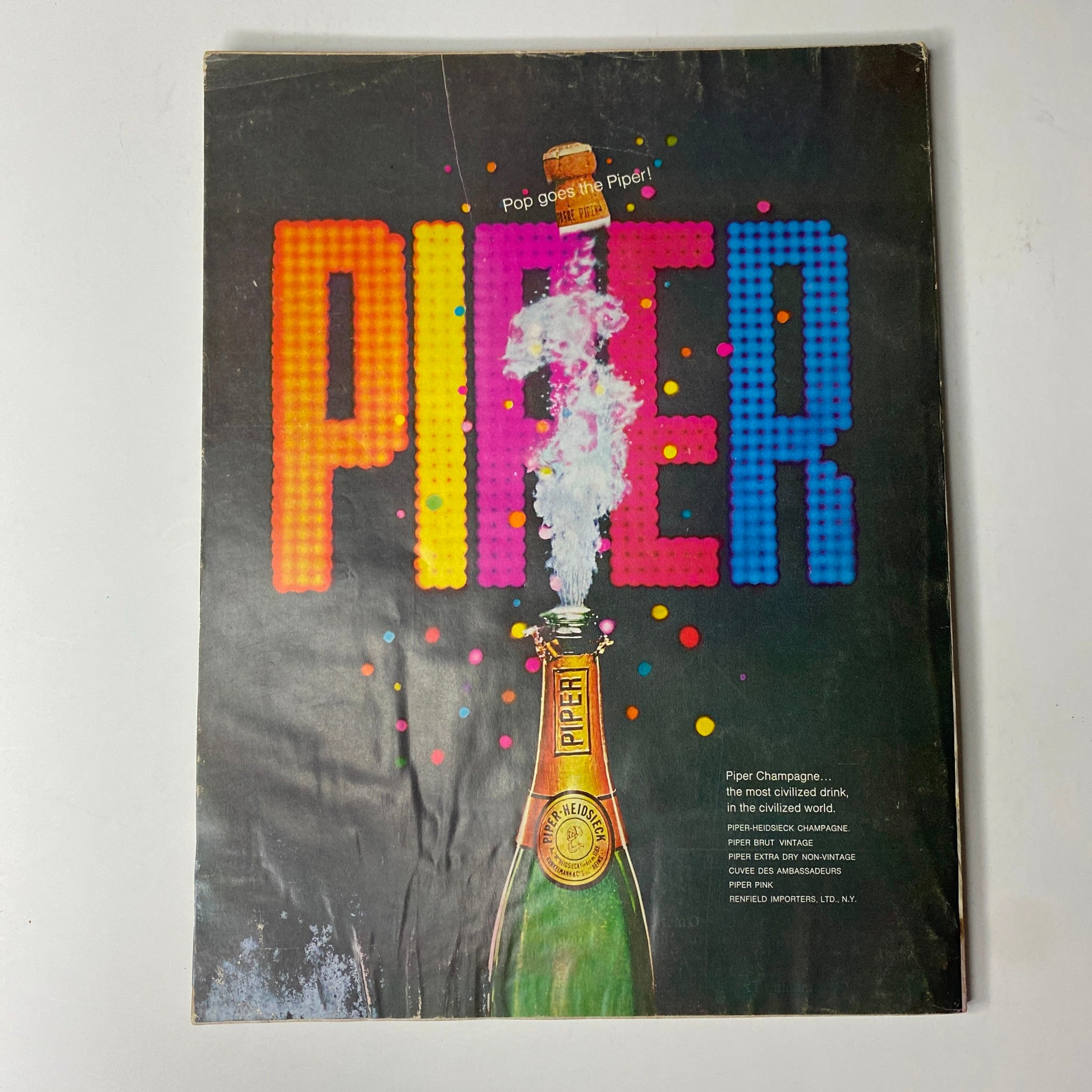 Back cover of Vogue Magazine June 1969 featuring an advertisement for Piper champagne with a colorful design and celebratory theme, indicative of 1960s fashion and lifestyle.