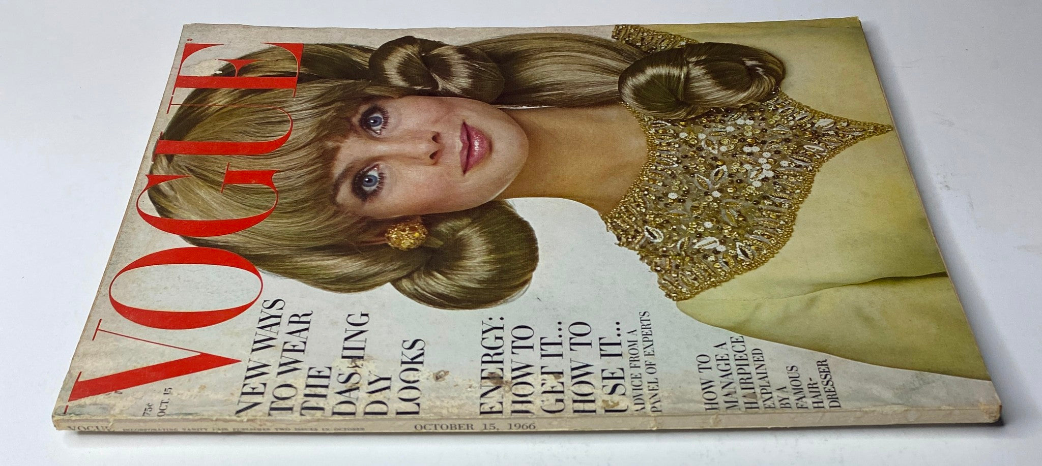 Vogue Magazine October 15, 1966 showcasing a close-up of the cover with a model in a glamorous hairstyle and a richly adorned outfit, highlighting fashion innovations of the era.