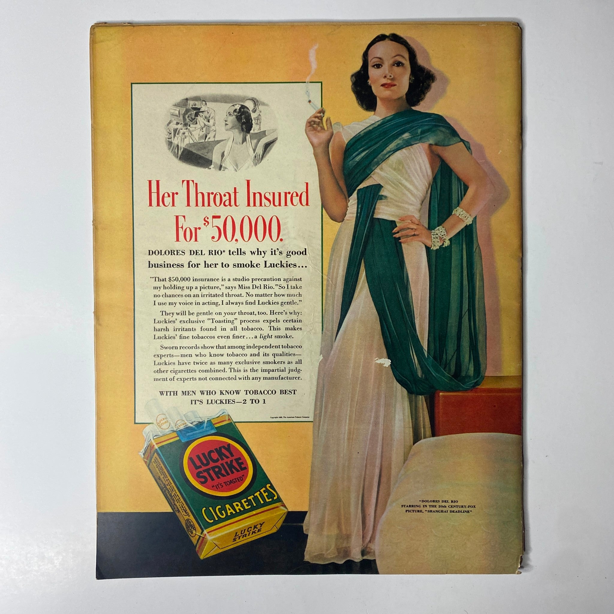 Vintage advertisement featuring Dolores Del Rio promoting Lucky Strike cigarettes, titled 'Her Throat Insured For $50,000' from Look Magazine February 15, 1938. The ad highlights the glamorous image of the actress wearing a stylish gown and discusses the insurance aspect of her smoking, emphasizing the intersection of celebrity culture and advertising in the 1930s.