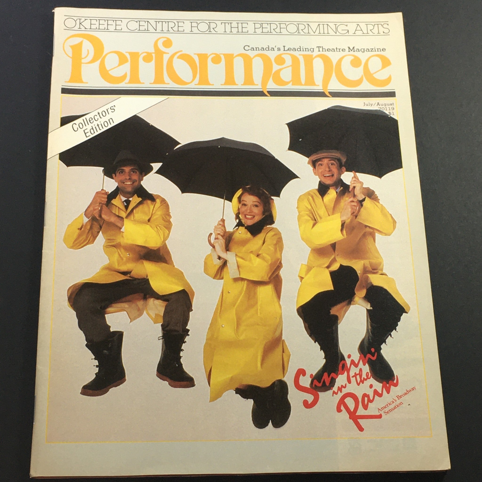 Vintage Performance Theatre Magazine, July-August 1986 issue featuring 'Singin' in the Rain' on Broadway. The cover shows three performers in yellow raincoats holding umbrellas.
