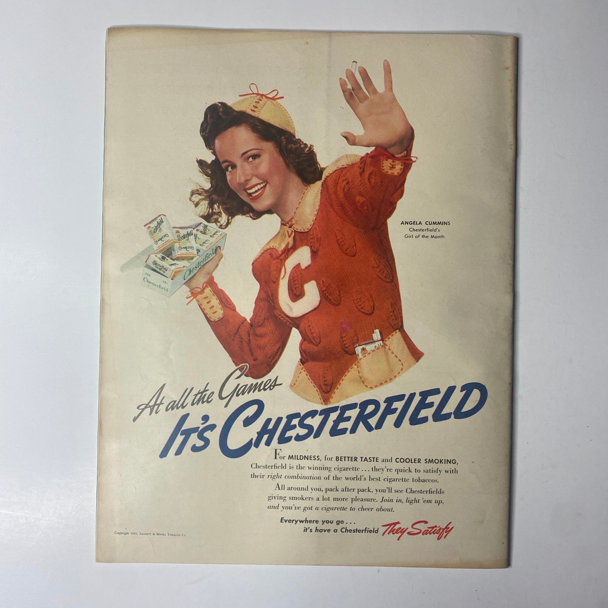 Advertisement for Chesterfield cigarettes in Look Magazine, October 7, 1941, featuring a smiling girl dressed as a cheerleader encouraging readers to enjoy Chesterfield.