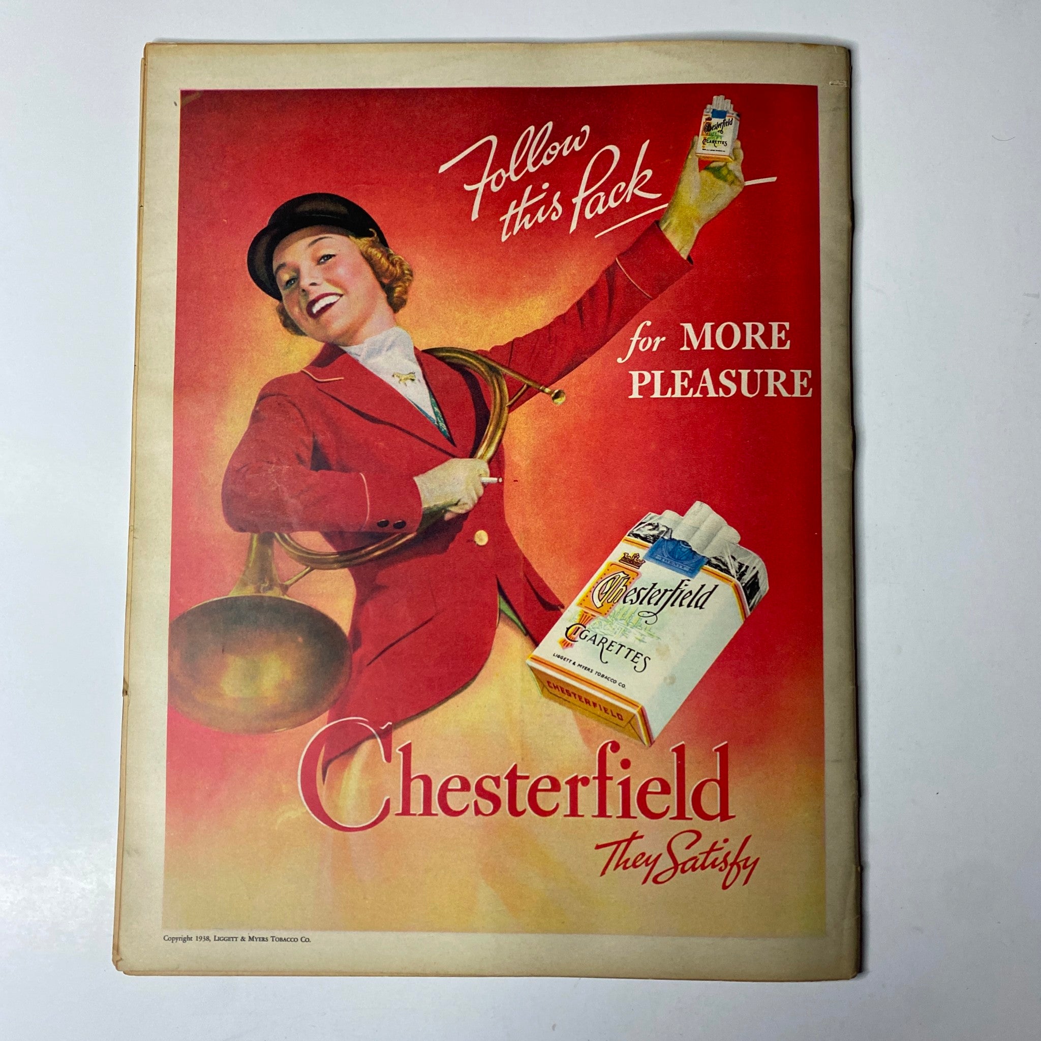 Vintage ad for Chesterfield cigarettes featured in Look Magazine March 15, 1938, showcasing a woman in red attire promoting the brand with the tagline 'Follow this Pack for More Pleasure'.