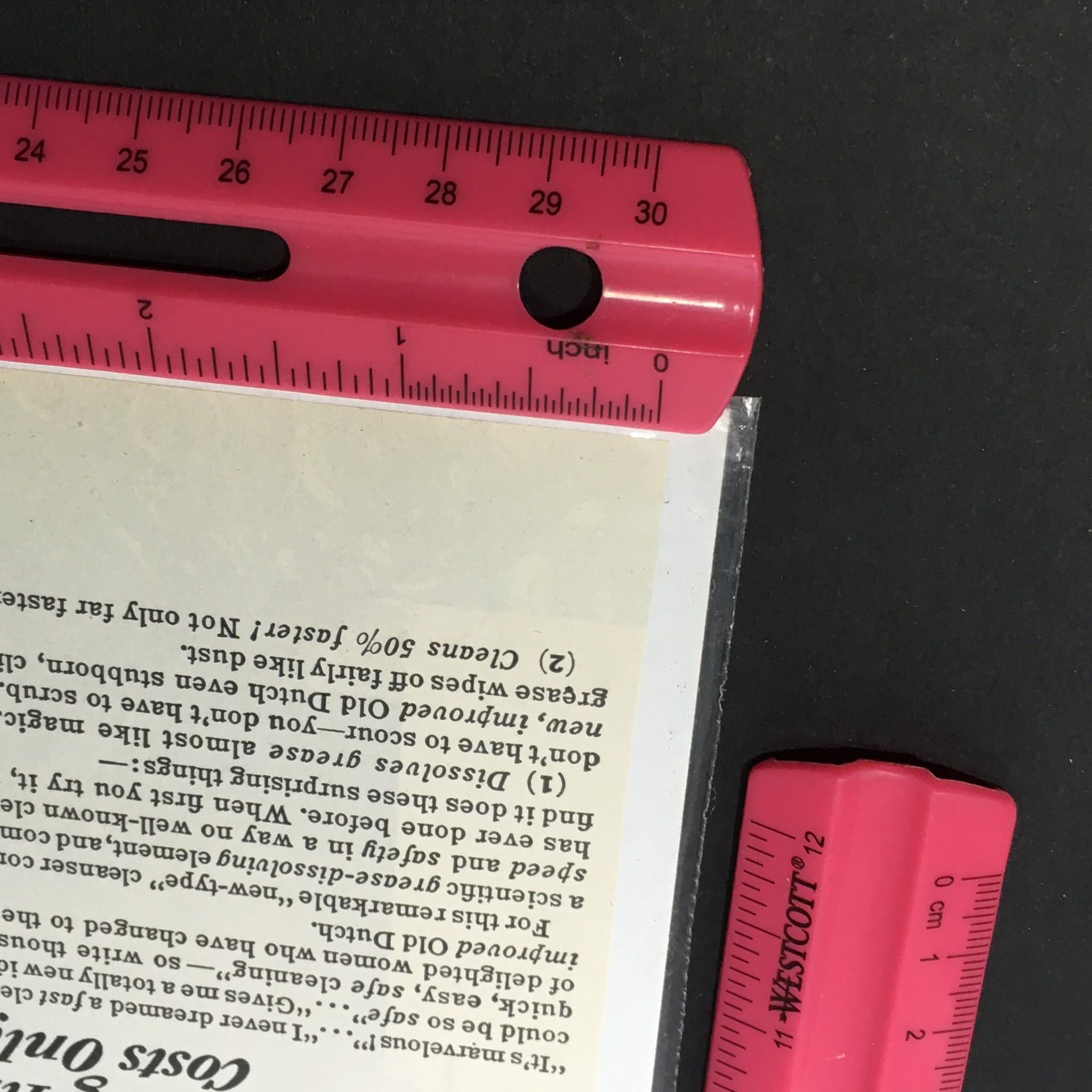 Close-up of the corner of the VTG 1940 Old Dutch Cleanser Made with Seismotite advertisement, featuring a ruler indicating size and showcasing meticulous preservation.