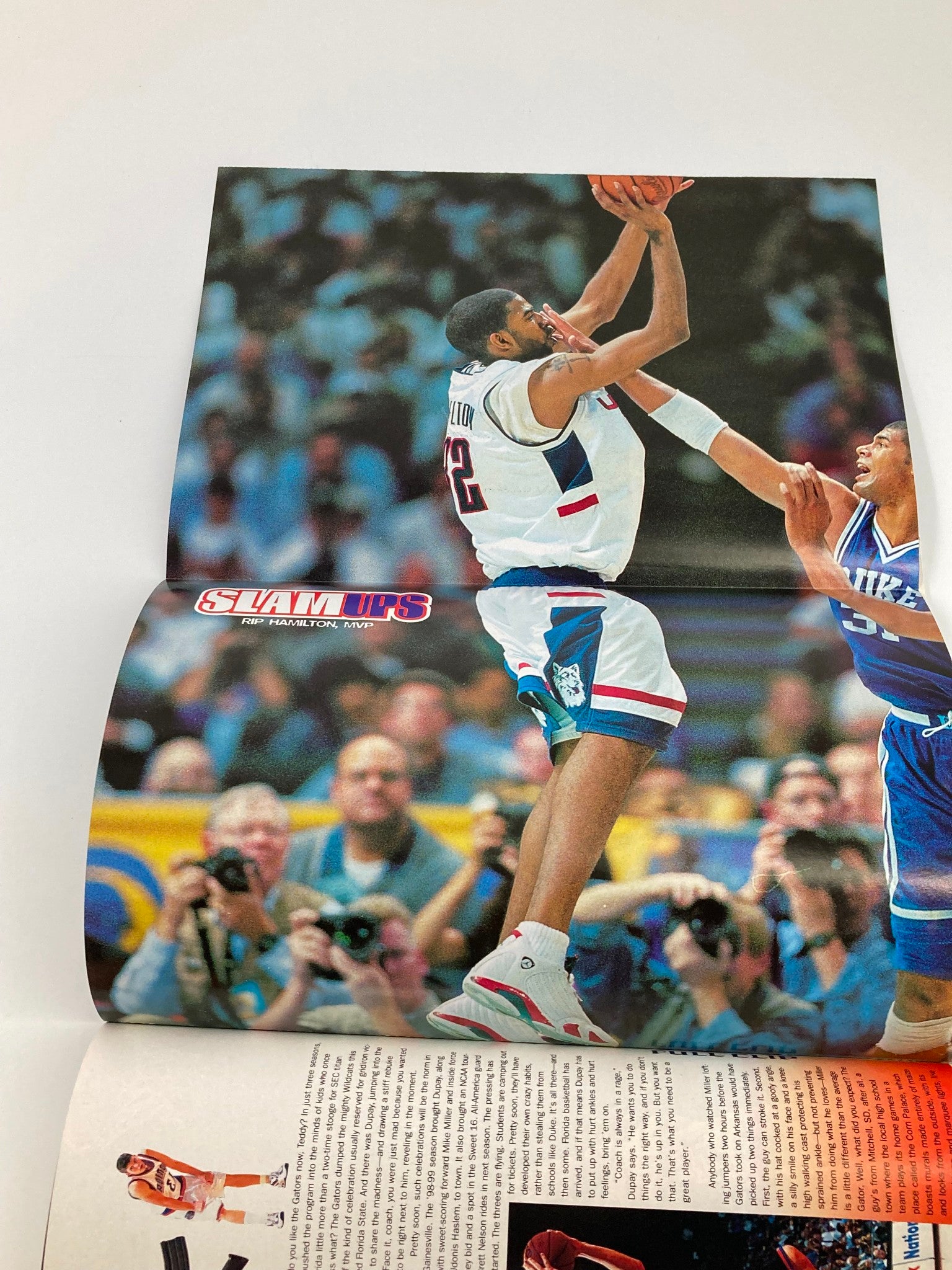 Poster from Slam Magazine August 1999, featuring a dynamic basketball scene with players in action, capturing the essence of competitive basketball culture.