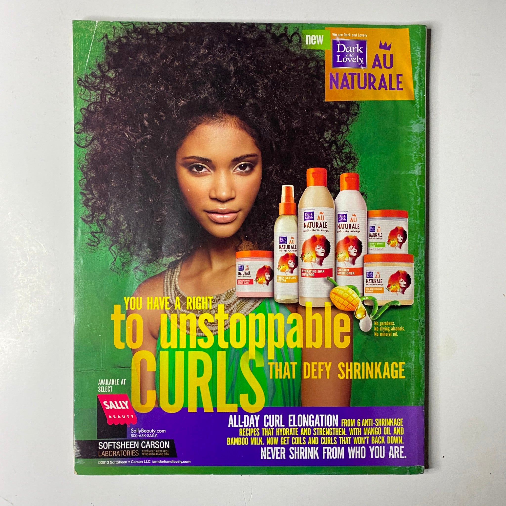 Cover image from Dark & Lovely Au Naturale featuring a woman with curly hair, promoting products designed for 'unstoppable curls that defy shrinkage'; included in Ebony Magazine September 2013.