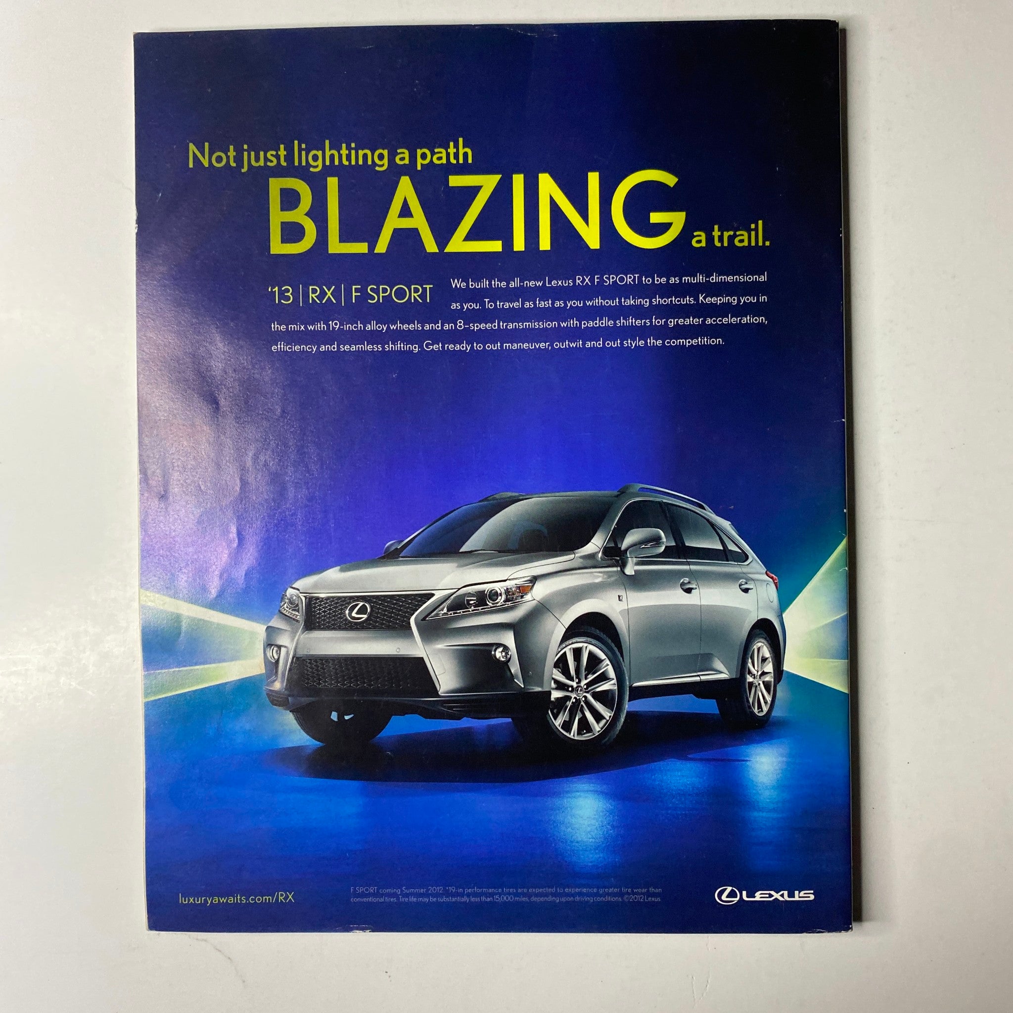 Advertisement for Lexus in Ebony Magazine July 2012, highlighting the 2013 RX model with a focus on luxury and performance.