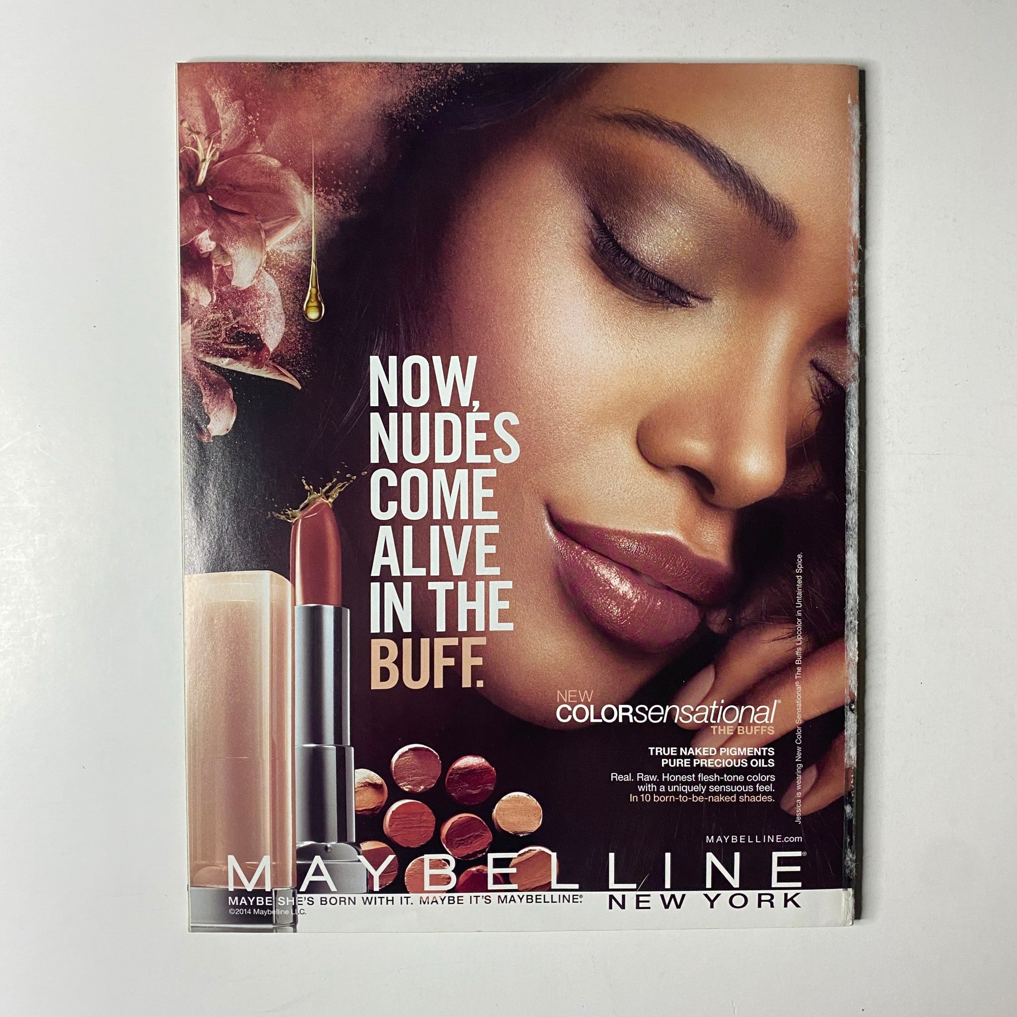 Maybelline advertisement from Ebony Magazine May 2014 Vol LXIX, No. 7, showcasing a stunning beauty campaign focused on nude shades and cosmetic products.