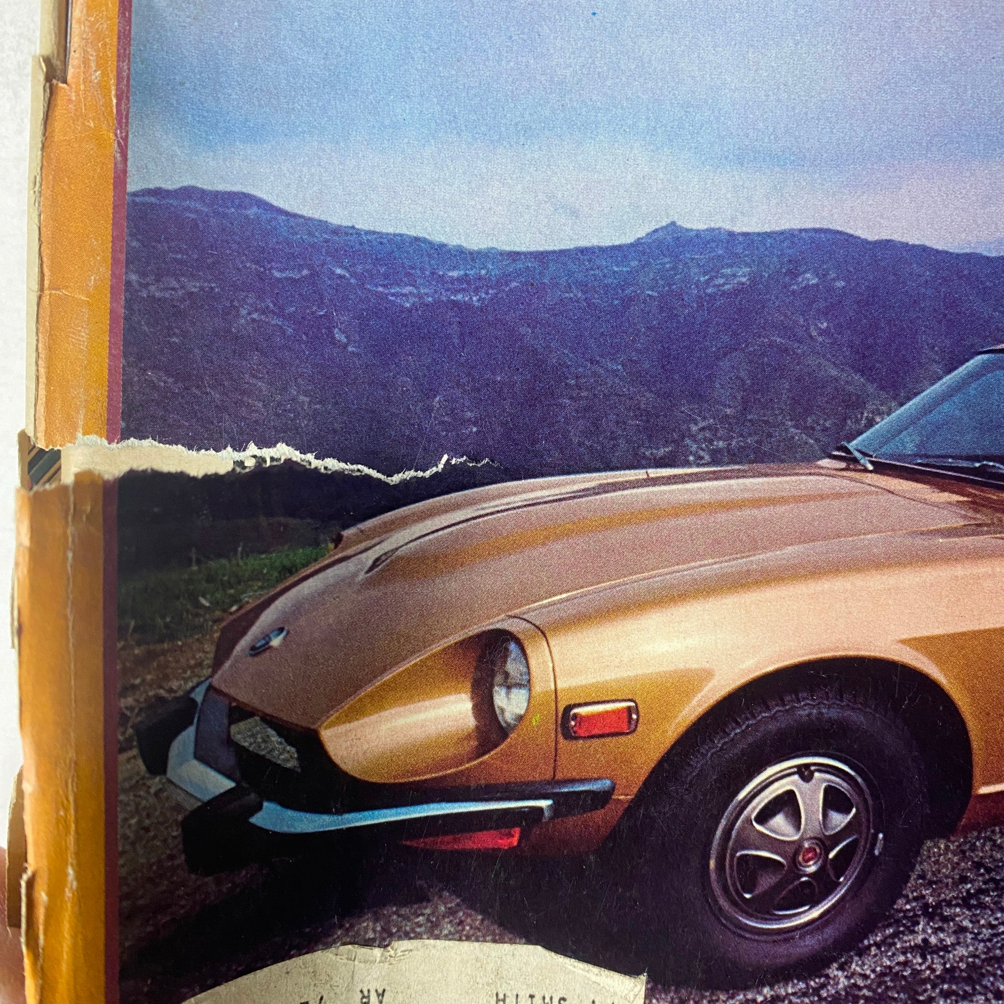 A close-up image of a damaged issue from the 1974 Car & Driver series, featuring a classic car in a scenic mountainous background, showcasing the vintage automotive aesthetic.