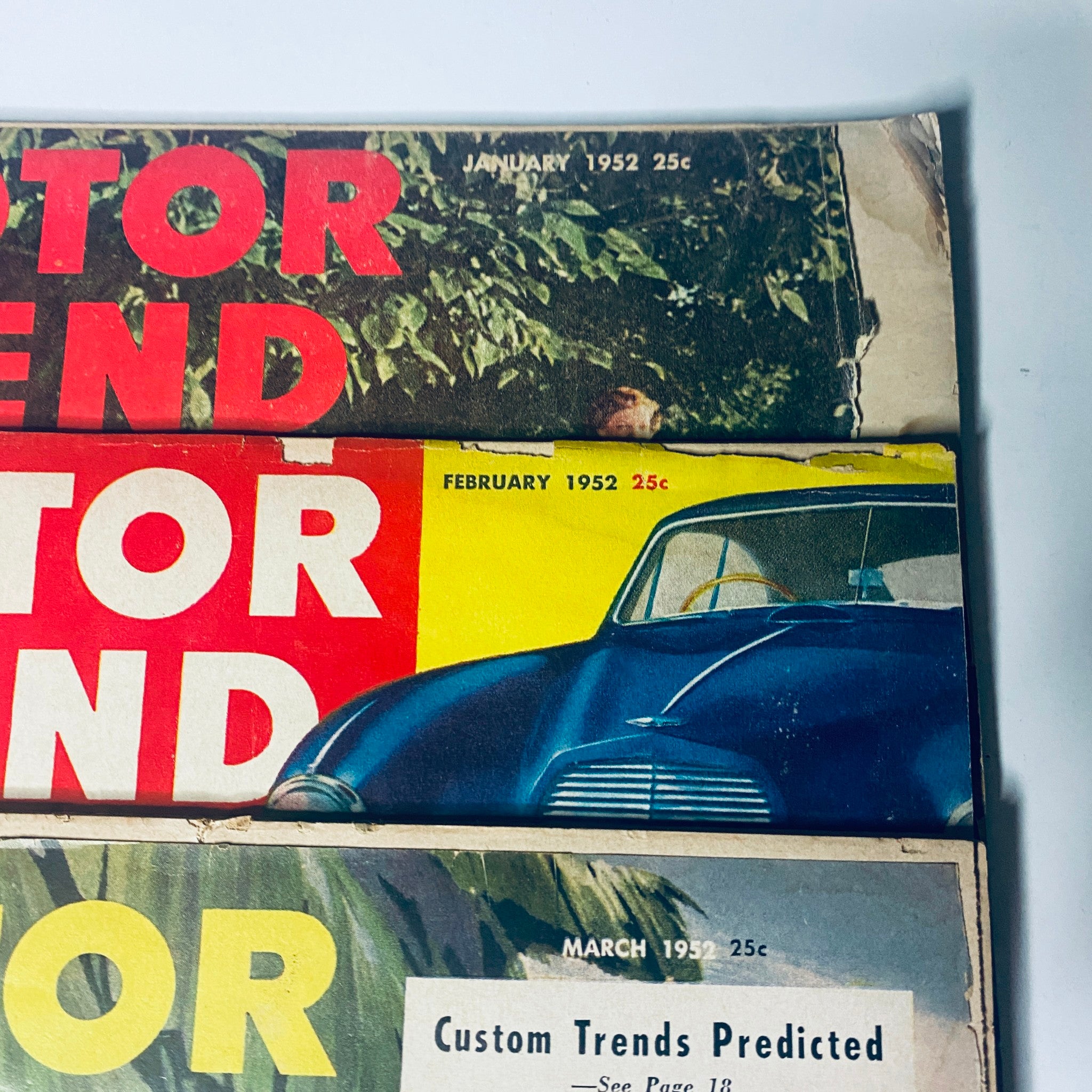 Close-up of Motor Trend Magazines from January, February, and March 1952, emphasizing vintage automobile presentations and design.