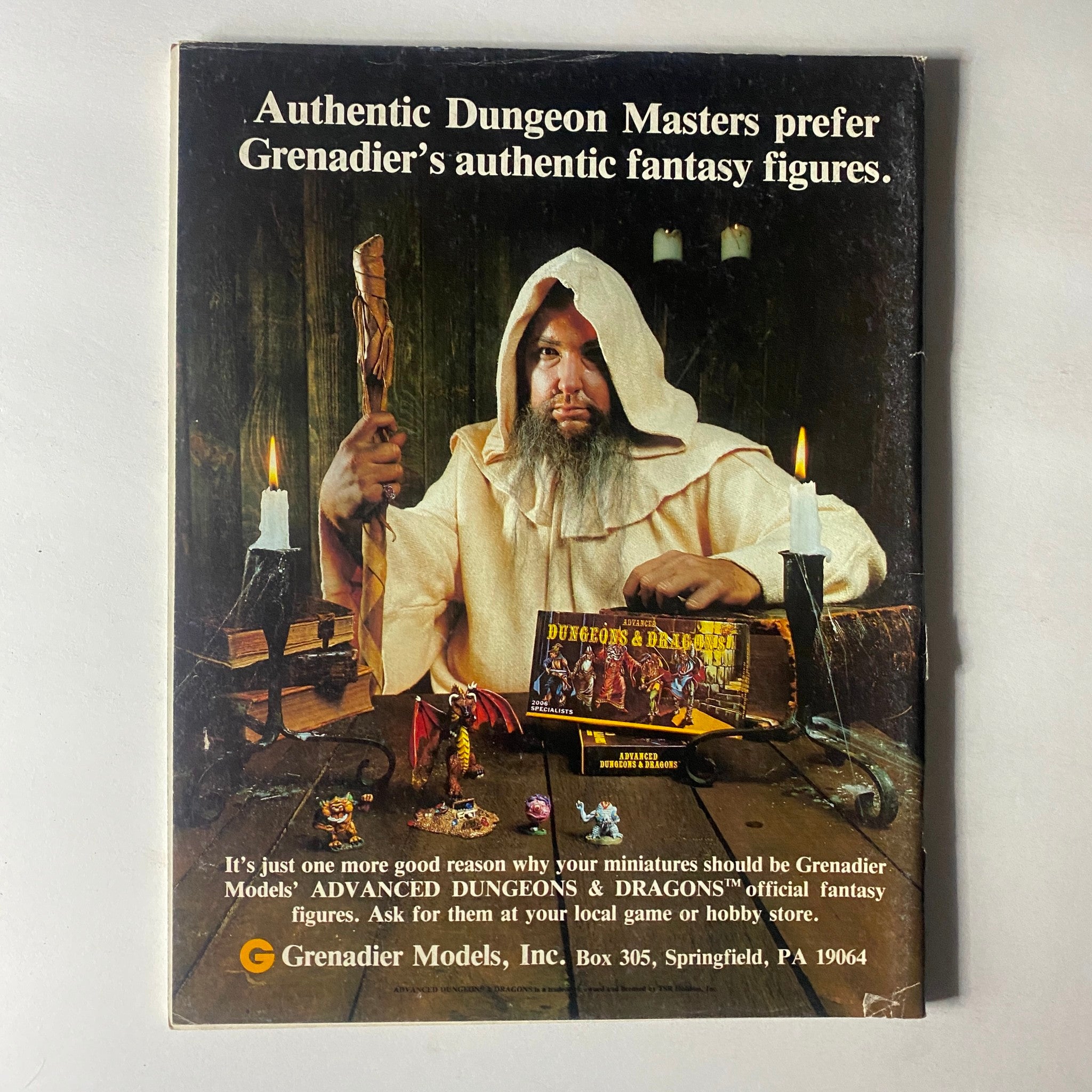 VTG Dragon Magazine June 1982 #61 Gnomes and Their Gods featuring an advertisement for Grenadier's Dungeons & Dragons fantasy figures, showcasing a wizard with a staff and various miniature figures on a table in a rustic setting.