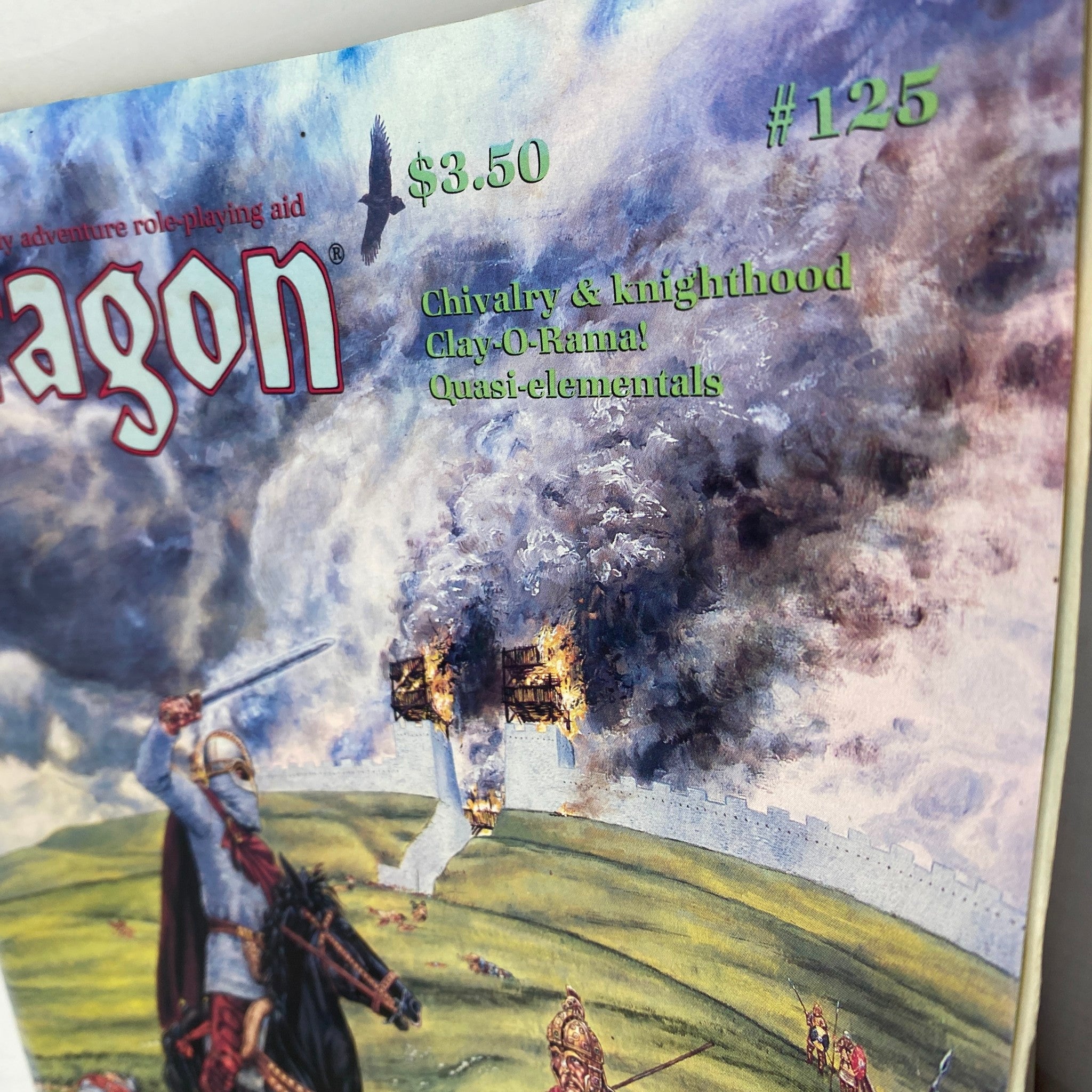 Close-up of the cover of VTG Dragon Magazine September 1987 #125 showcasing the title and key features including 'Chivalry & knighthood' illustrated with a dramatic background of a siege.