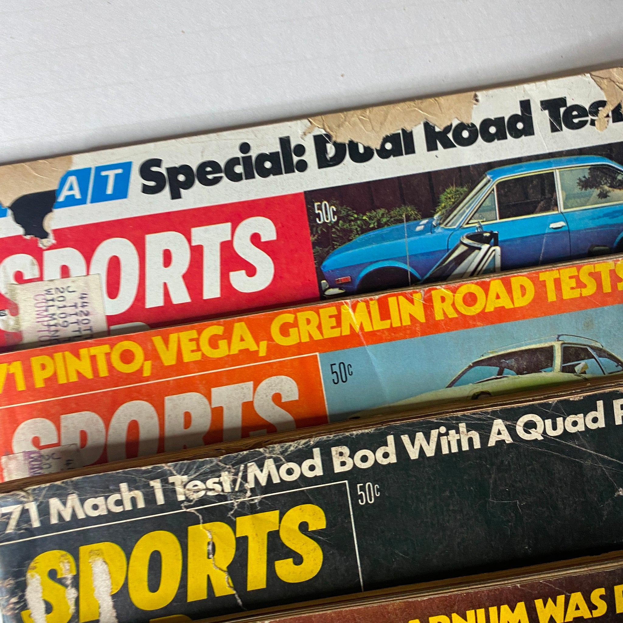 Various covers of Sports Car Graphic magazines from 1970 featuring multiple classic cars, with visible wear on the pages. Lot of 10 Sports Car Graphic Magazine 1970 January - April, July - December.