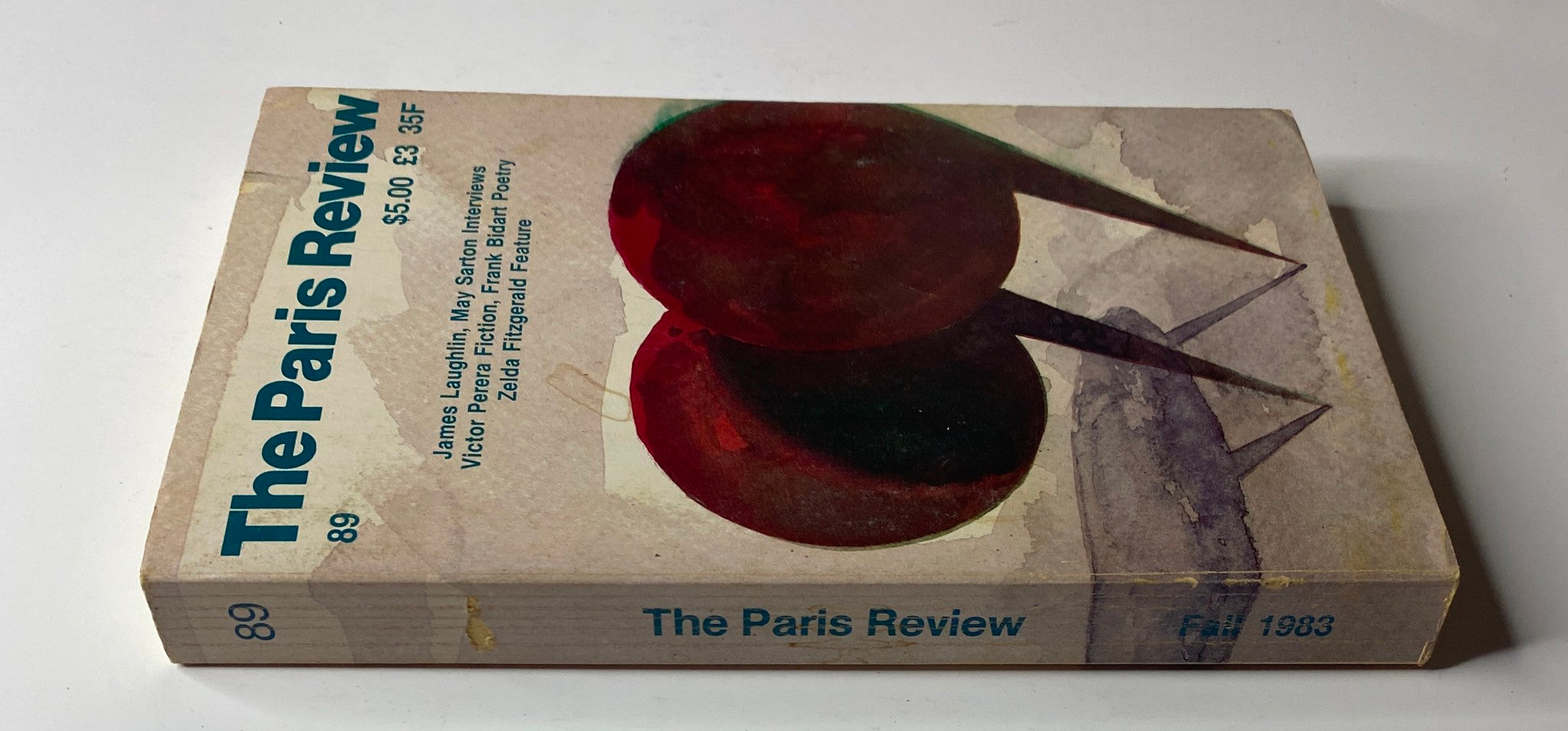 Side view of The Paris Review Magazine, Fall 1983, No. 89, showcasing the spine and cover art that includes two red speech bubbles.