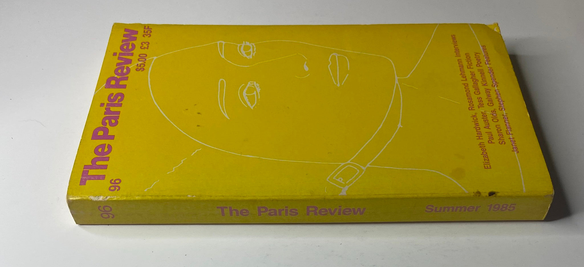 Side view of The Paris Review Magazine Summer 1985 No. 96, highlighting its yellow spine with the issue number and title, showcasing its vintage aesthetic.
