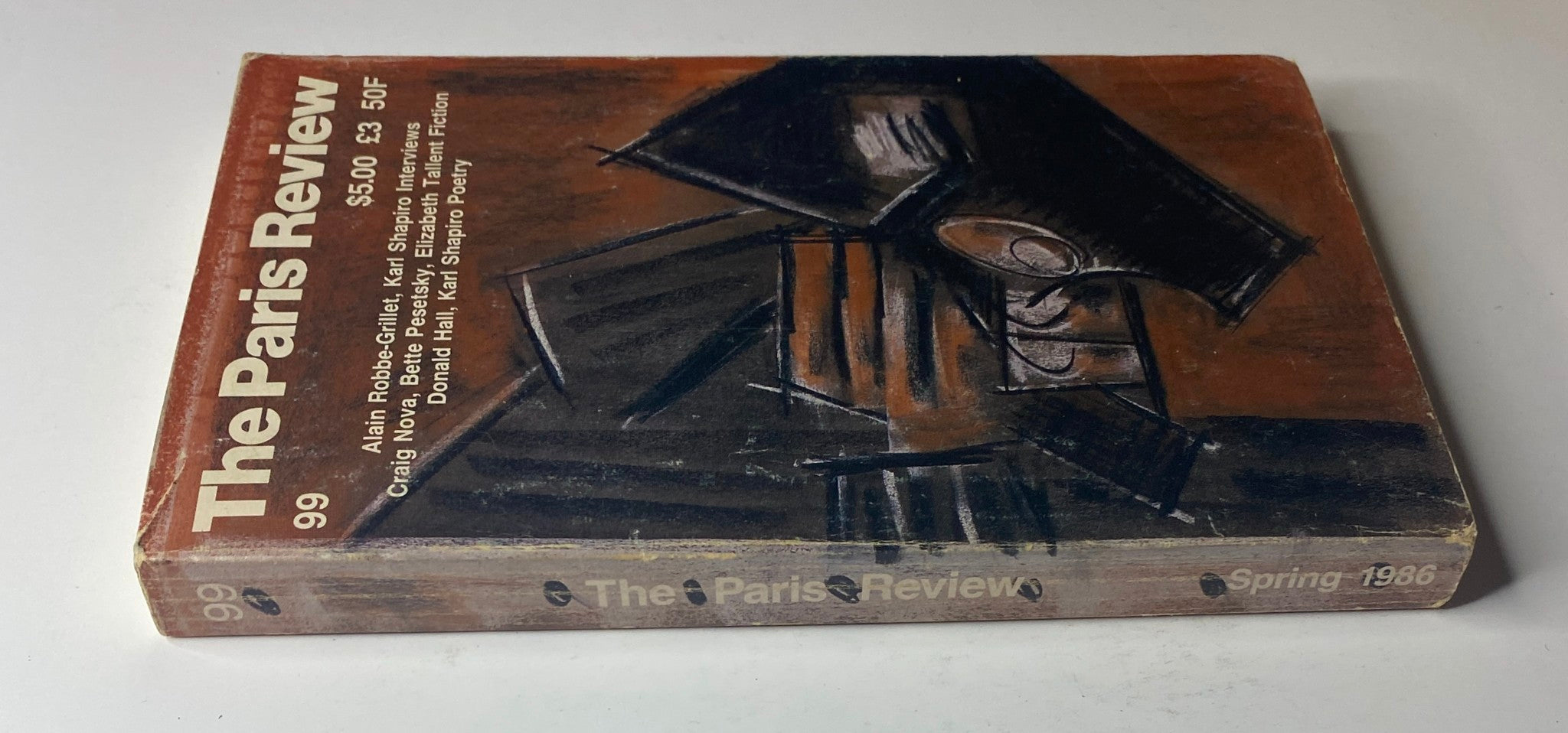 Cover of The Paris Review Magazine Spring 1986 No. 99 featuring artwork, highlighting Alain Robbe-Grillet and Karl Shapiro.