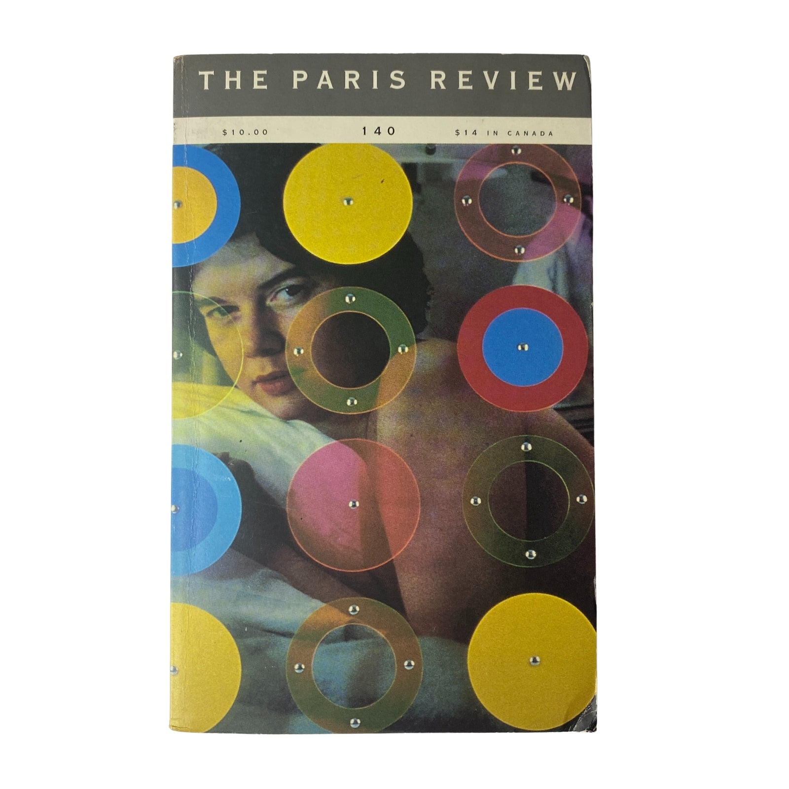 Cover of The Paris Review Magazine Fall 1996 No. 140 featuring colorful circles and a photograph of a young woman. This edition highlights Bernard Cooper's work.