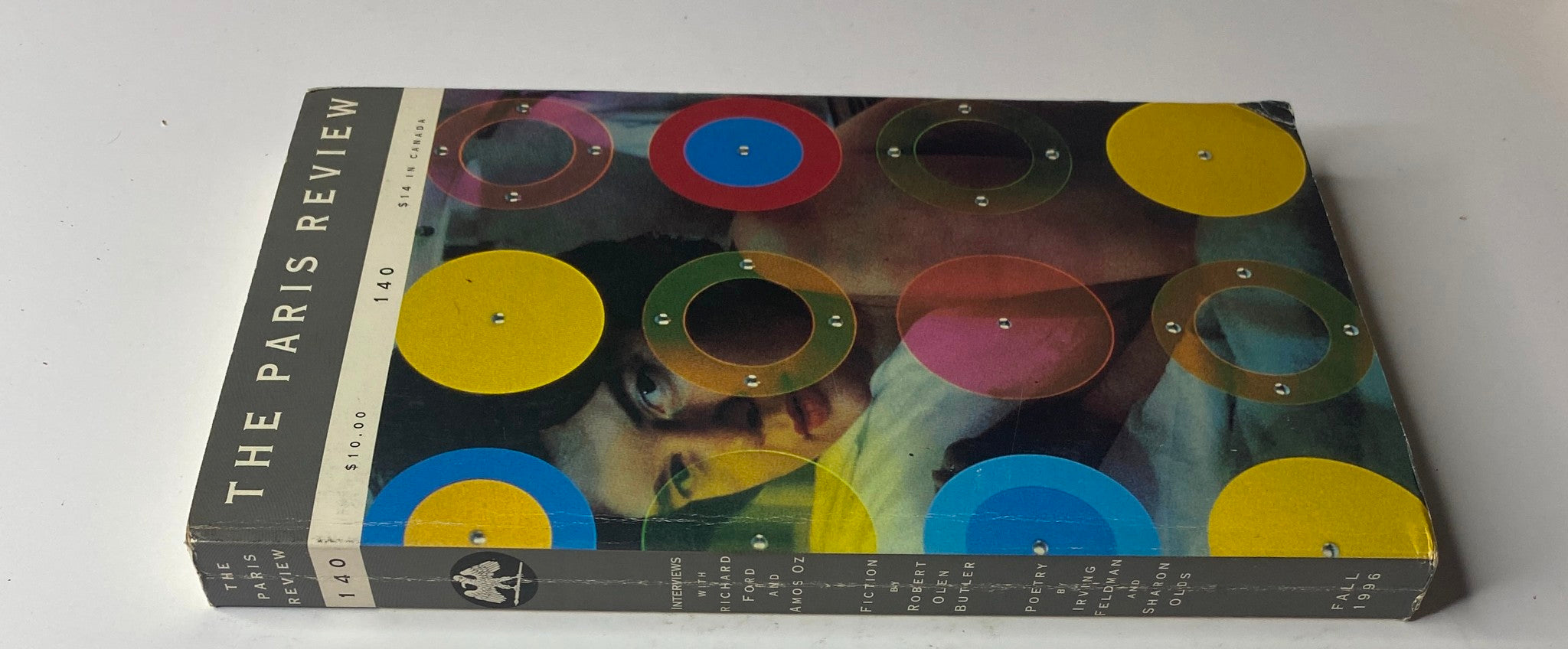 Side view of The Paris Review Magazine Fall 1996 No. 140 showcasing colorful circular designs and featuring content by notable authors including Bernard Cooper, Richard Ford, and Amos Oz.