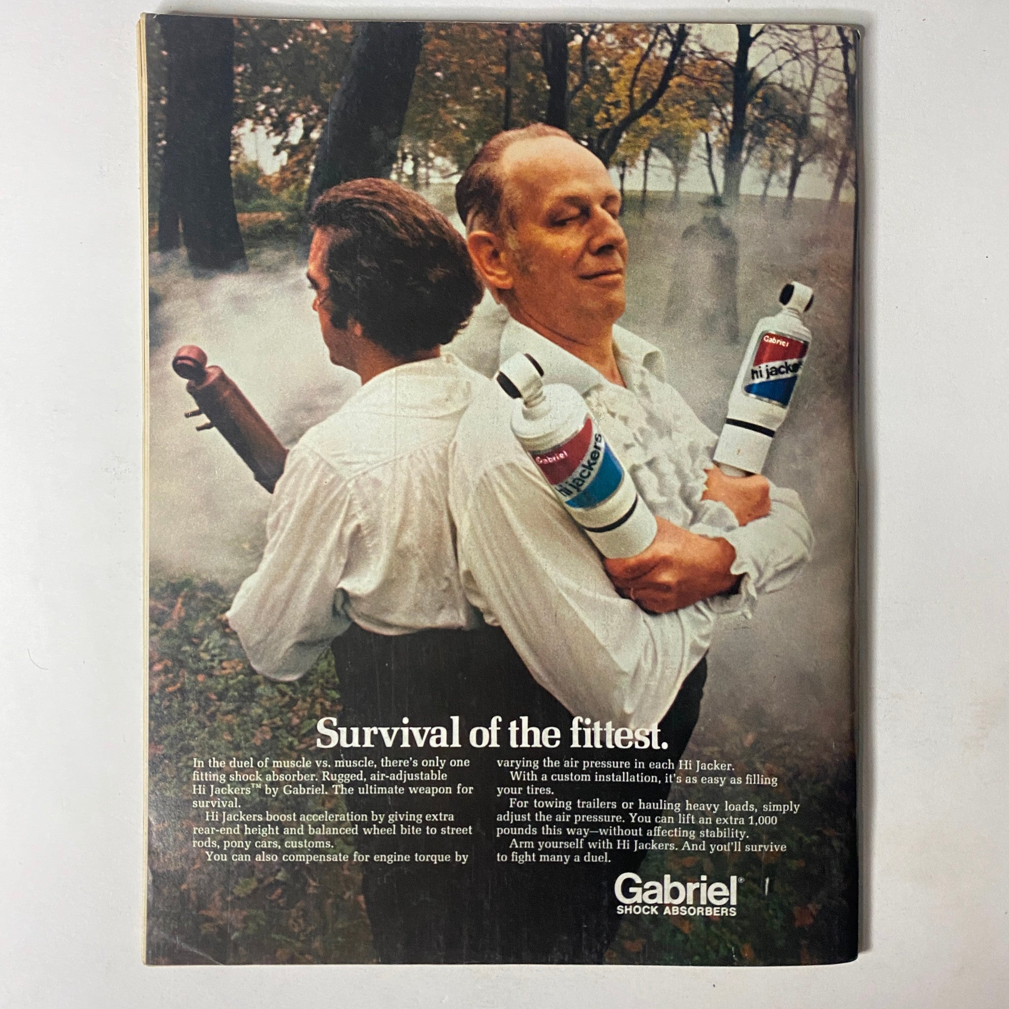 Advertisement from Car Craft Magazine July 1972 for Gabriel shock absorbers, illustrating the tagline 'Survival of the fittest' with actors holding shock bottles.