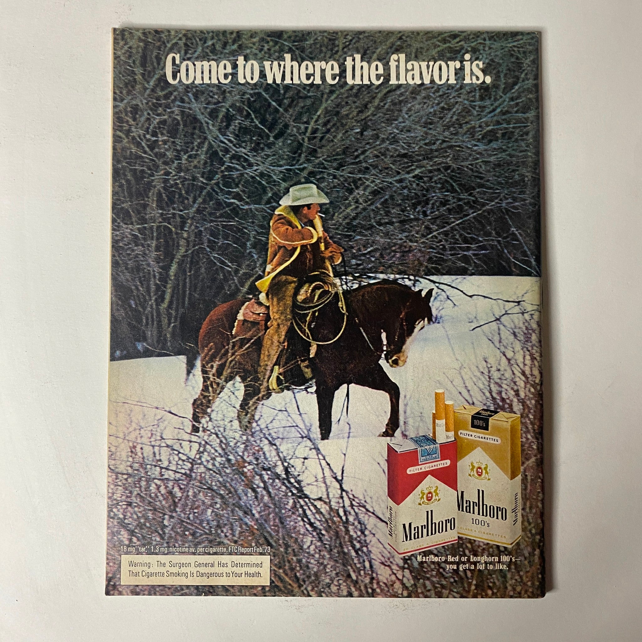 Vintage Marlboro advertisement featuring a cowboy on horseback, published in Car Craft Magazine December 1973, promoting tobacco products amidst classic Americana.