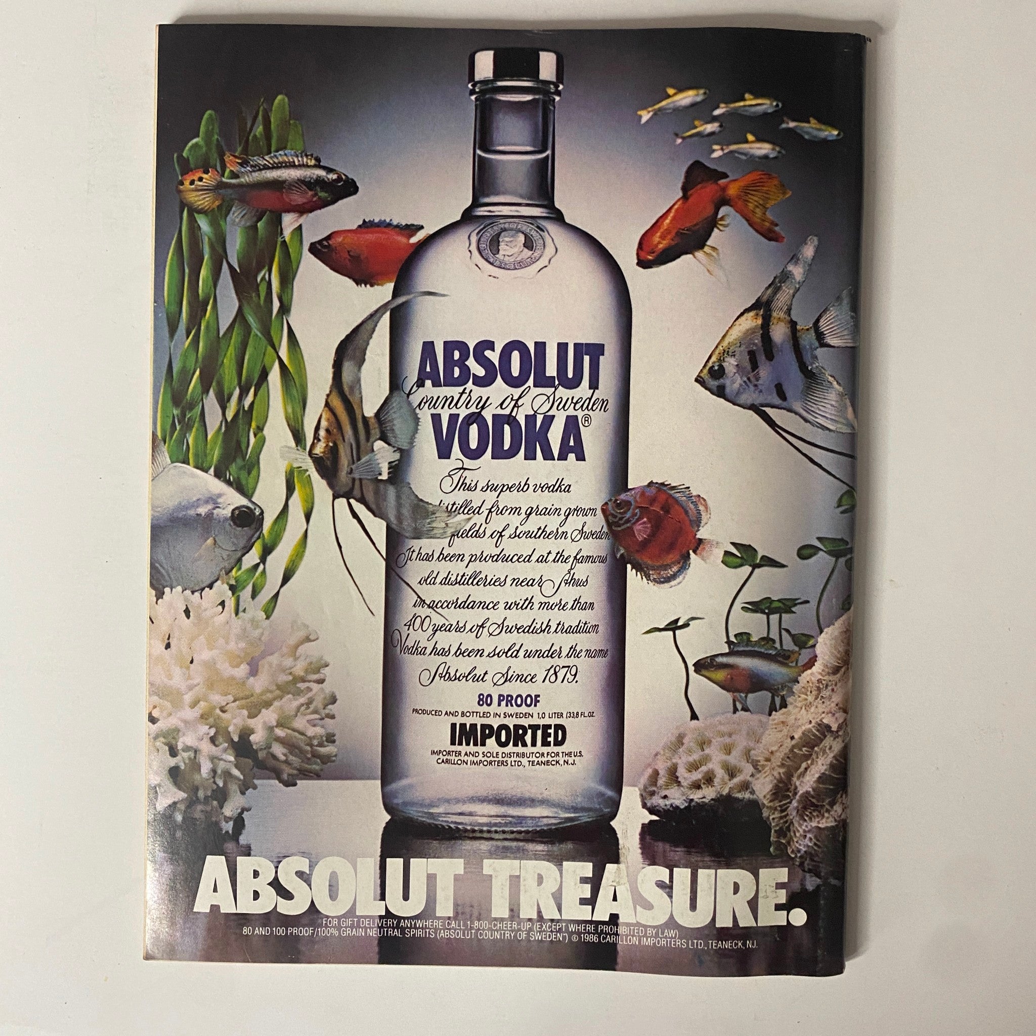 Advertisement for Absolut Vodka in Forbes Magazine October 6, 1986, showcasing the bottle amidst fish and aquatic plants, promoting its Swedish heritage.