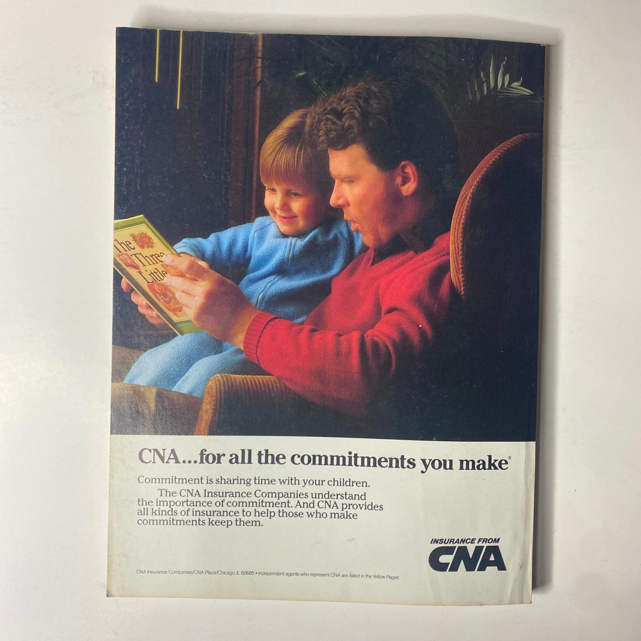 Advert for CNA Insurance in Forbes Magazine 1986, featuring a father reading to his child, emphasizing familial commitment and the importance of insurance coverage.