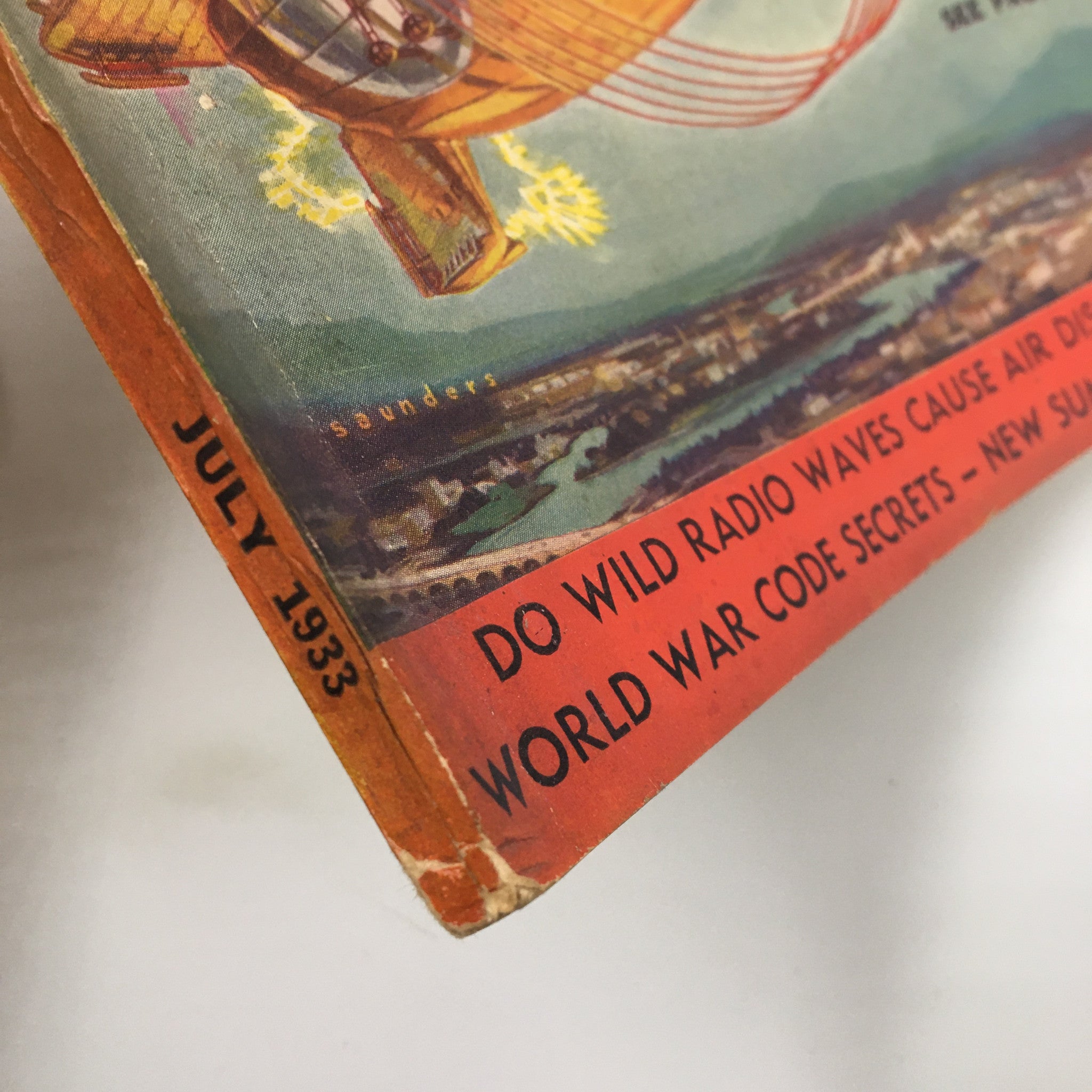 Close-up view of the spine of the July 1933 magazine 'Modern Mechanix and Inventions', highlighting its vintage title and mention of World War Code Secrets.