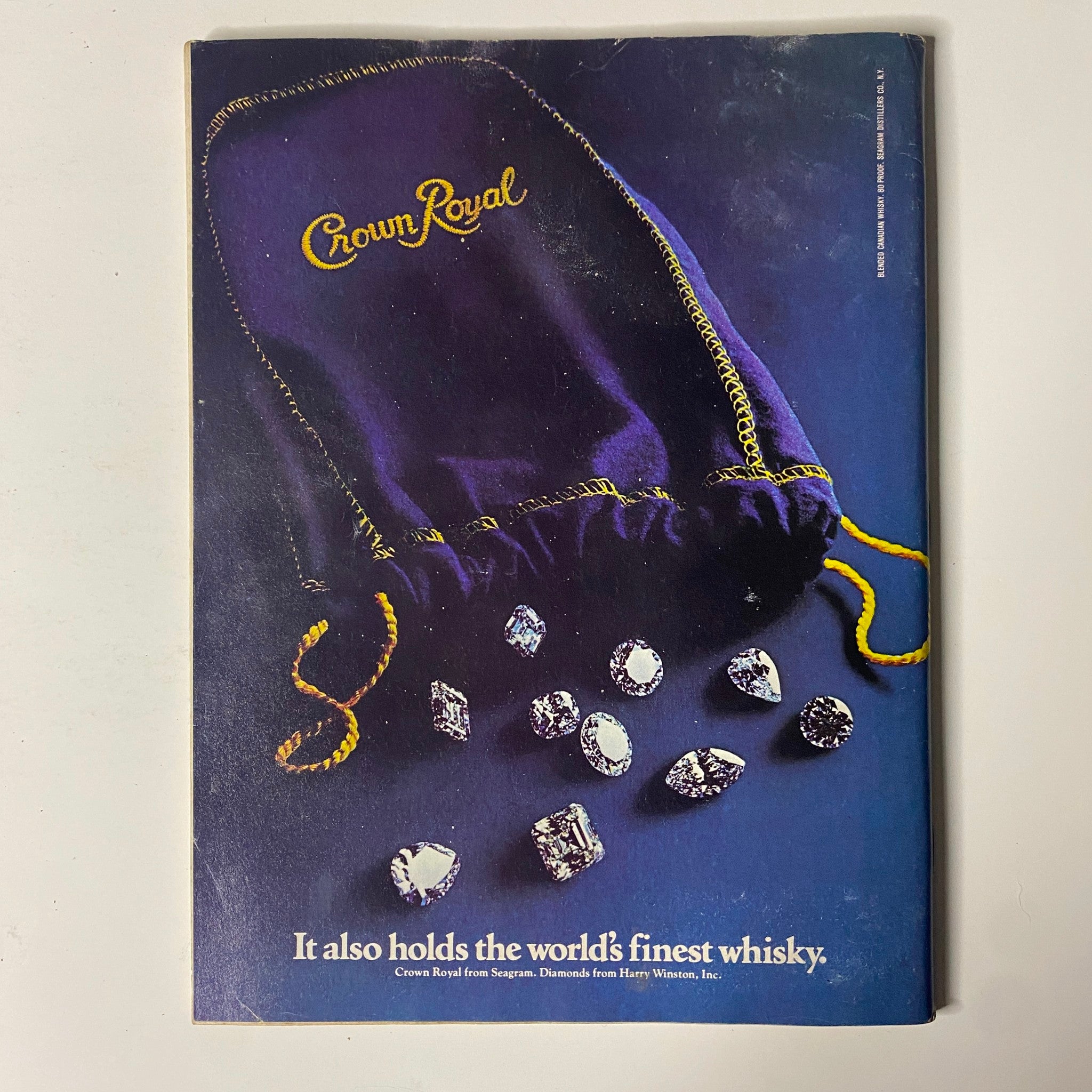 Cover of Forbes Magazine, February 15, 1982, featuring Crown Royal whisky advertisement. The image showcases a luxurious purple bag with the Crown Royal logo, surrounded by sparkling gems, highlighting the tagline 'It also holds the world's finest whisky.'