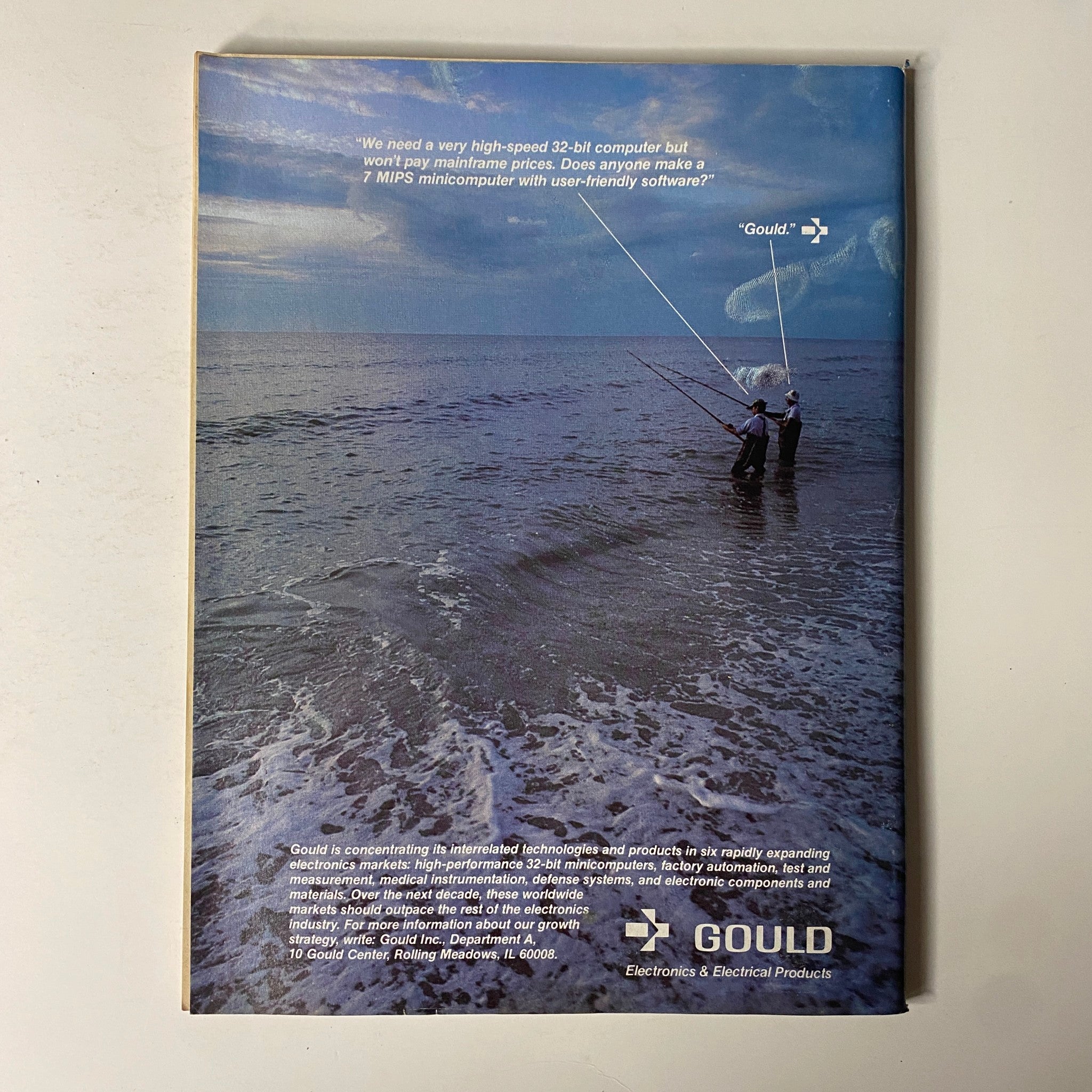 Back cover of Forbes Magazine dated March 14, 1983, featuring a photo of two fishermen on the beach with a quote about high-speed computers, highlighting the advertisement for Gould Electronics & Electrical Products.
