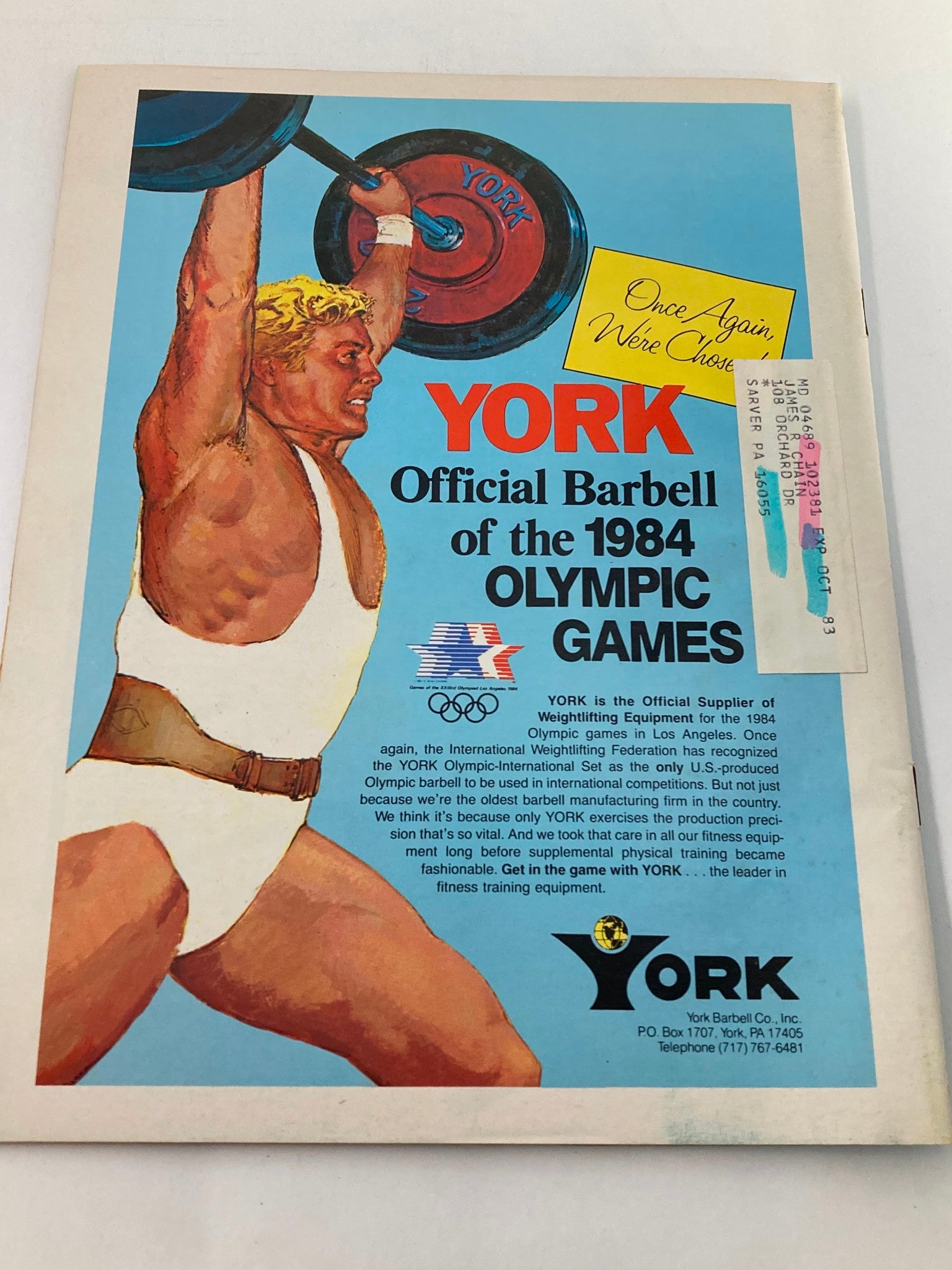Advertisement page in VTG Muscular Development Magazine August 1983 for York's official barbell of the 1984 Olympic Games, featuring a strongman lifting weights.