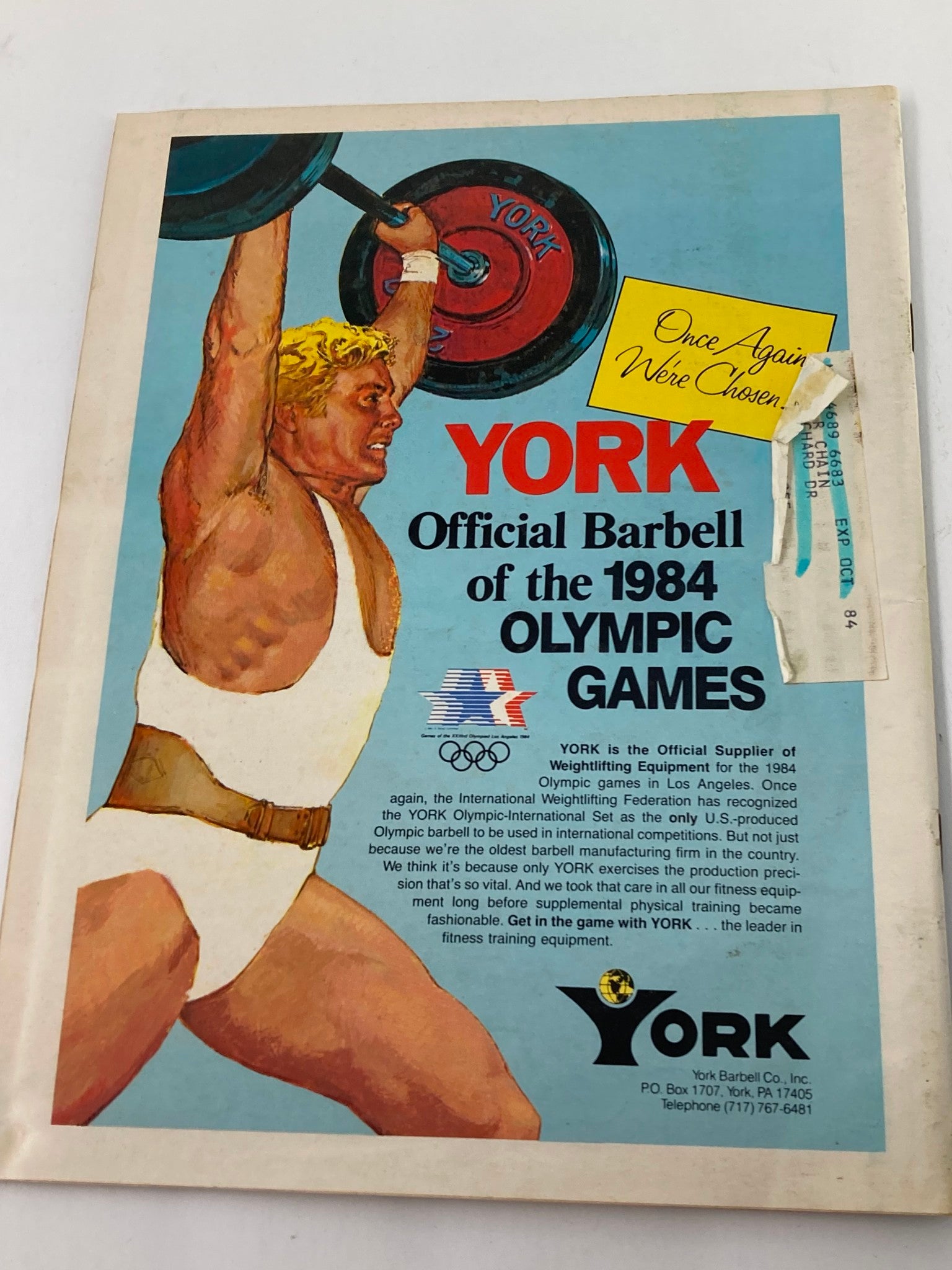 Back cover of VTG Muscular Development Magazine December 1983 showing an advertisement for York Barbell, emphasizing their role in the 1984 Olympic Games.