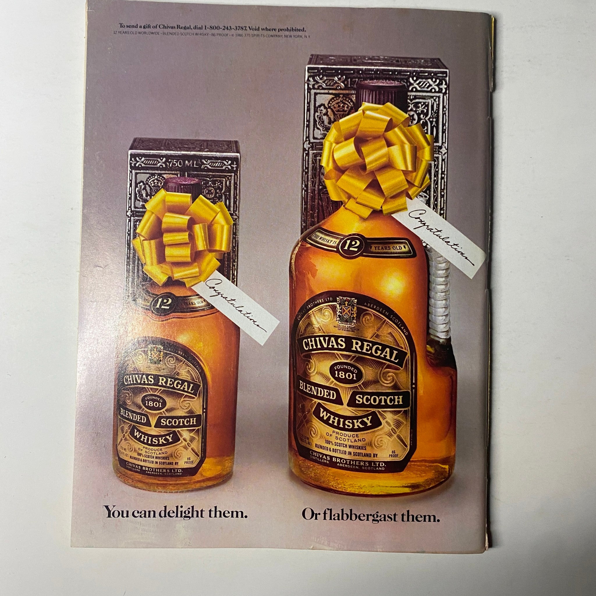 Chivas Regal whisky advertisement from May 1987 Forbes Magazine, showcasing two elegantly wrapped bottles with yellow bows and a slogan promoting gifting options.