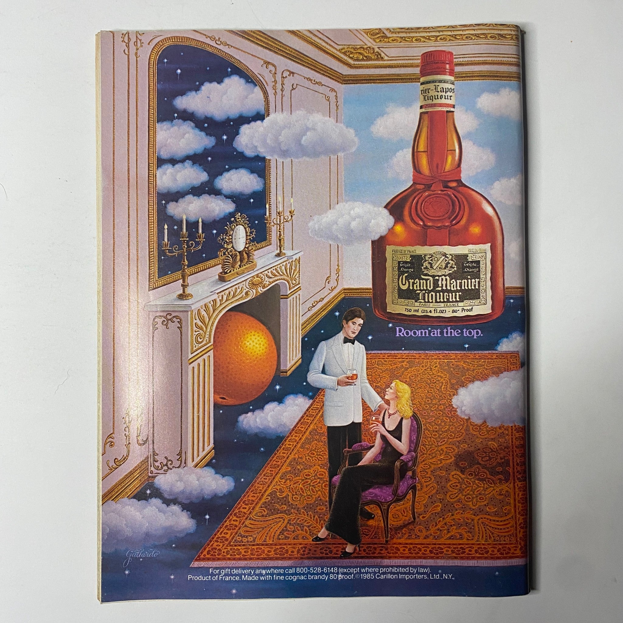 Colorful advertisement featuring a man in a tuxedo offering a drink to a woman seated, set in a lavish room with an artistic design, including an oversized bottle of Grand Marnier liquor, with the caption 'Room at the top'. Related to the Forbes Magazine September 9, 1985 issue discussing Credit Card Scams: They’re Out To Get You.
