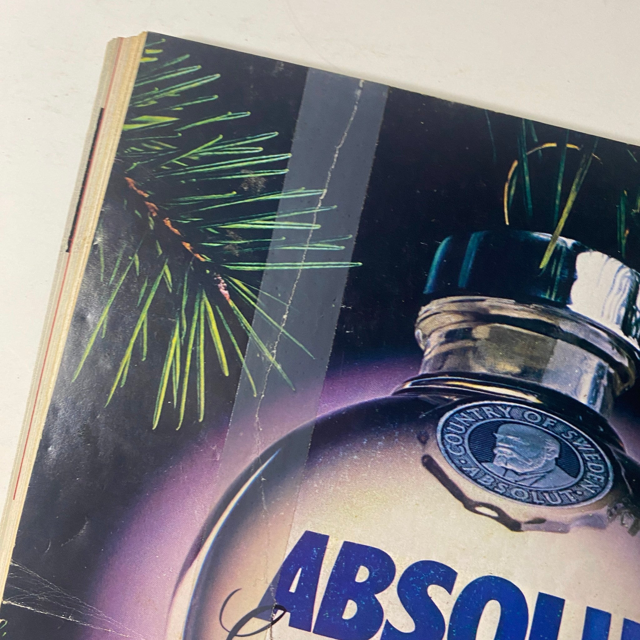 Close-up view of an advertisement from Forbes Magazine December 14, 1987, highlighting the Absolut Vodka bottle and branding details.