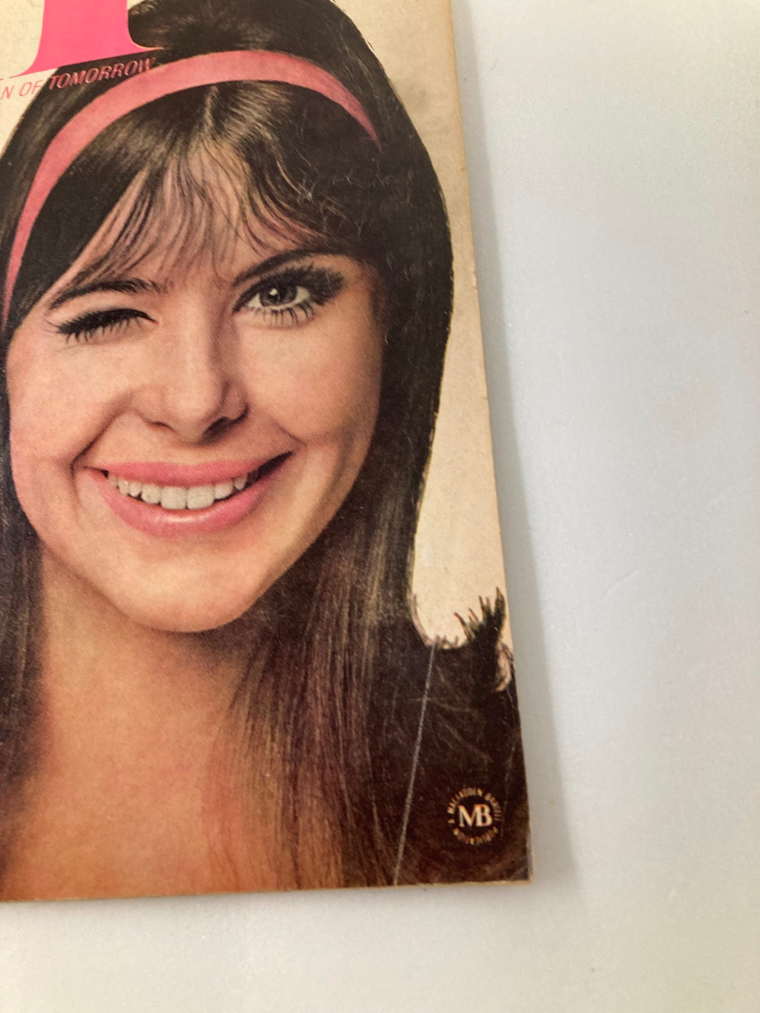 Close-up of the cover of VTG IN Magazine June 1966, Volume 2, Issue 4, highlighting a young woman's smile and wink, emphasizing the magazine's focus on youth culture and fashion.