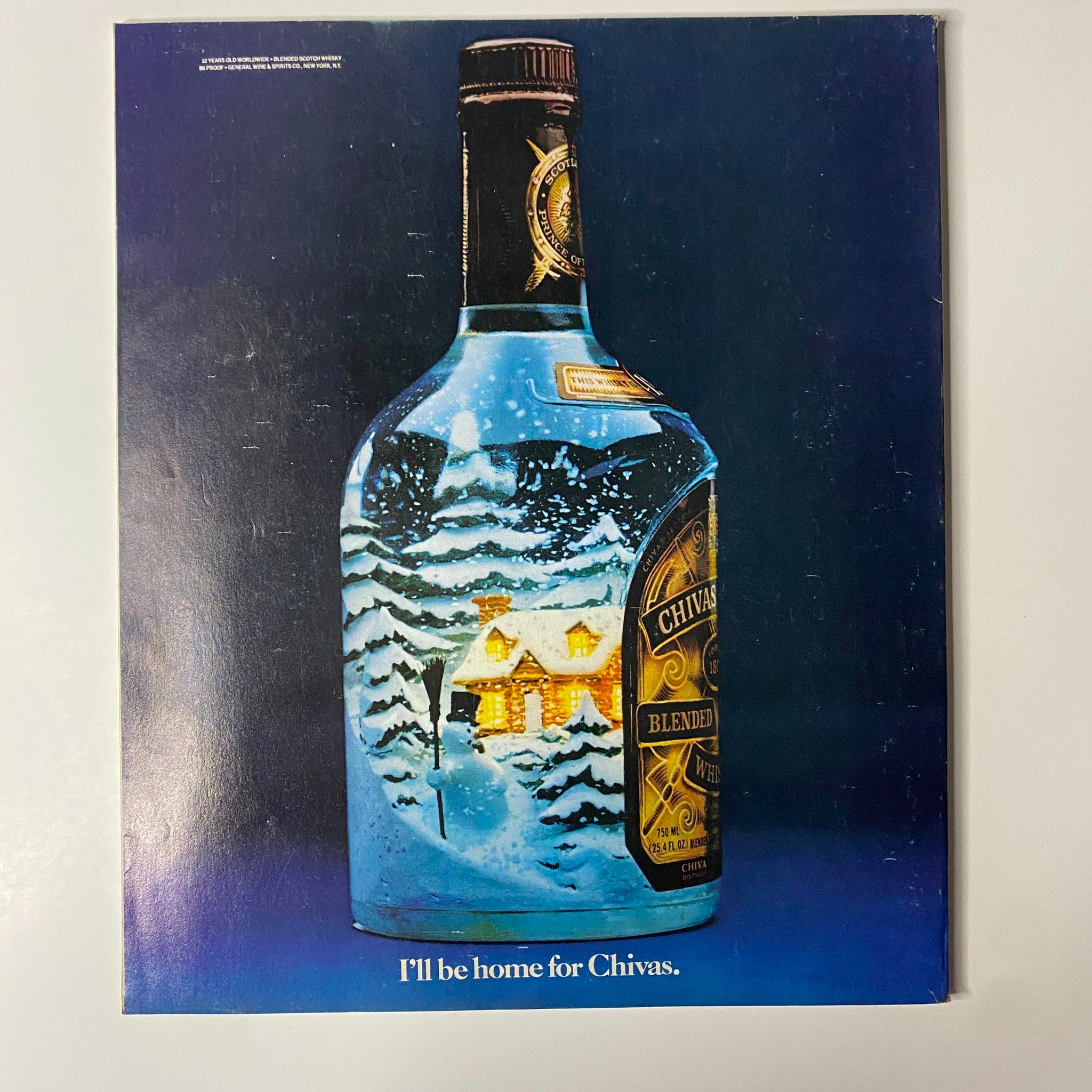 Advert for Chivas Regal blended whisky from Fortune Magazine December 28, 1981, showing a bottle with a festive winter scene and the tagline 'I'll be home for Chivas'.
