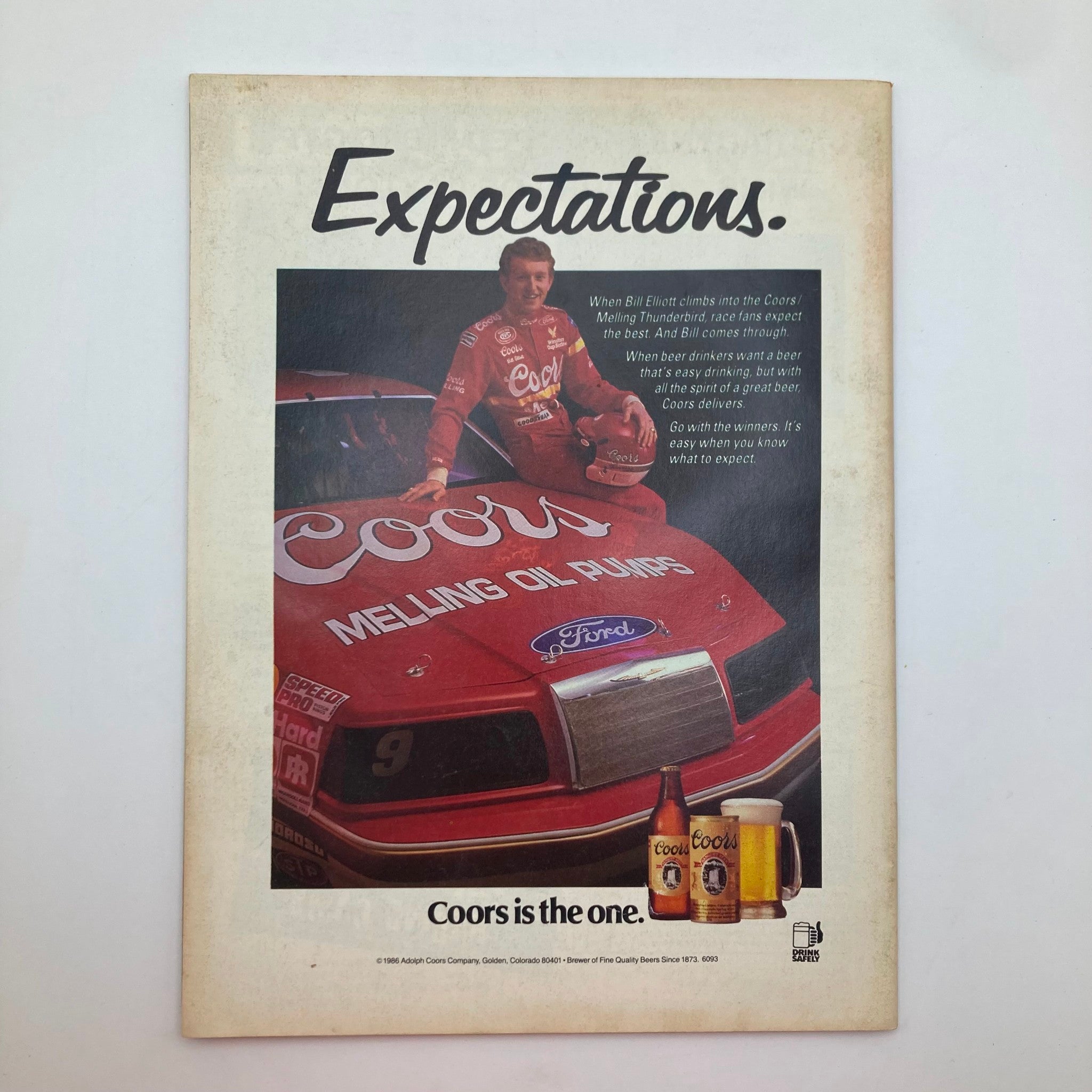 Back cover of the VTG Stock Car Racing Magazine July 1987, featuring a Coors Beer advertisement with Bill Elliott posing beside the Coors Melling Oil Ford car, highlighting racing culture and advertising from the late 1980s.