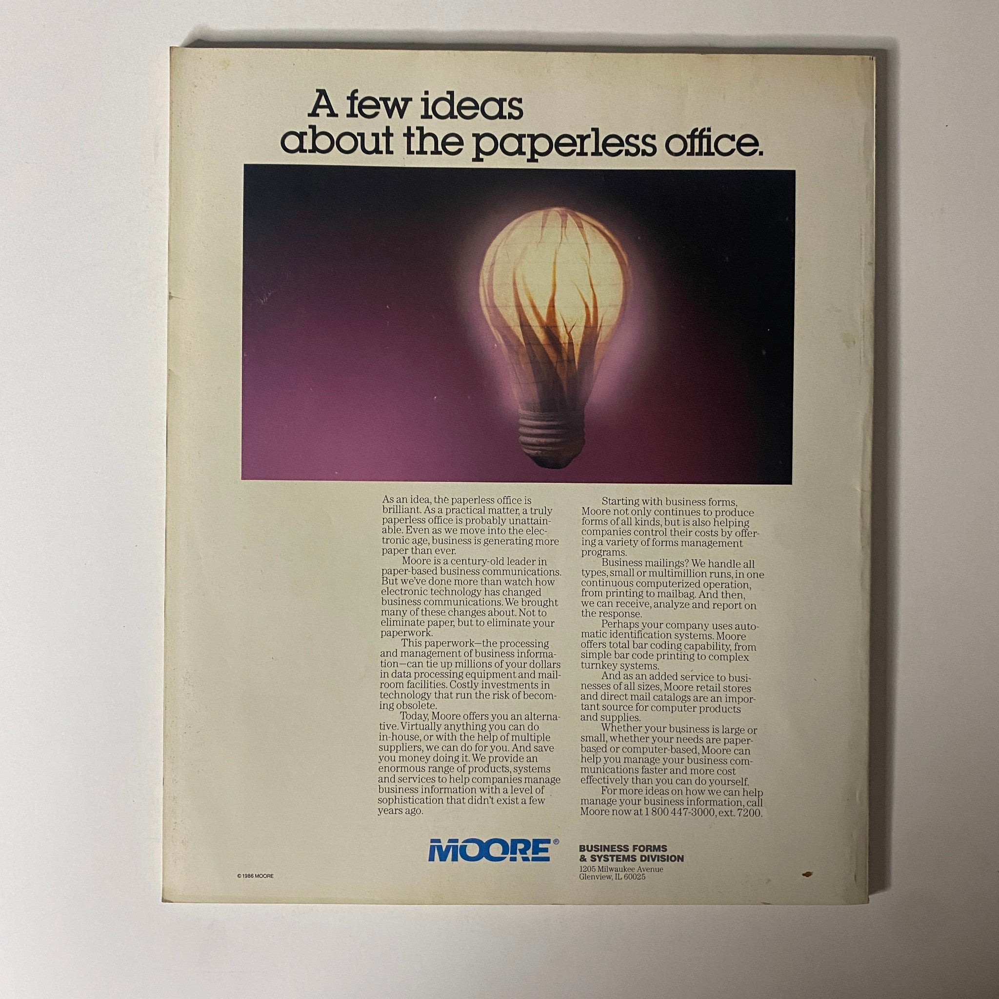 Back cover of Fortune Magazine June 23, 1986 with an advertisement discussing the concept of a 'paperless office'. The design features a lightbulb illuminating the idea of modern business efficiency.