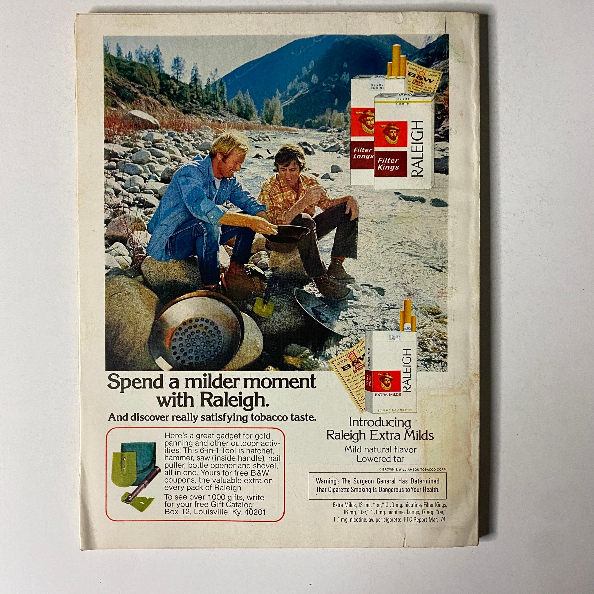 Advertisement from Esquire Magazine November 1974 featuring Raleigh cigarettes, promoting a milder smoking experience alongside a scenic outdoor backdrop.