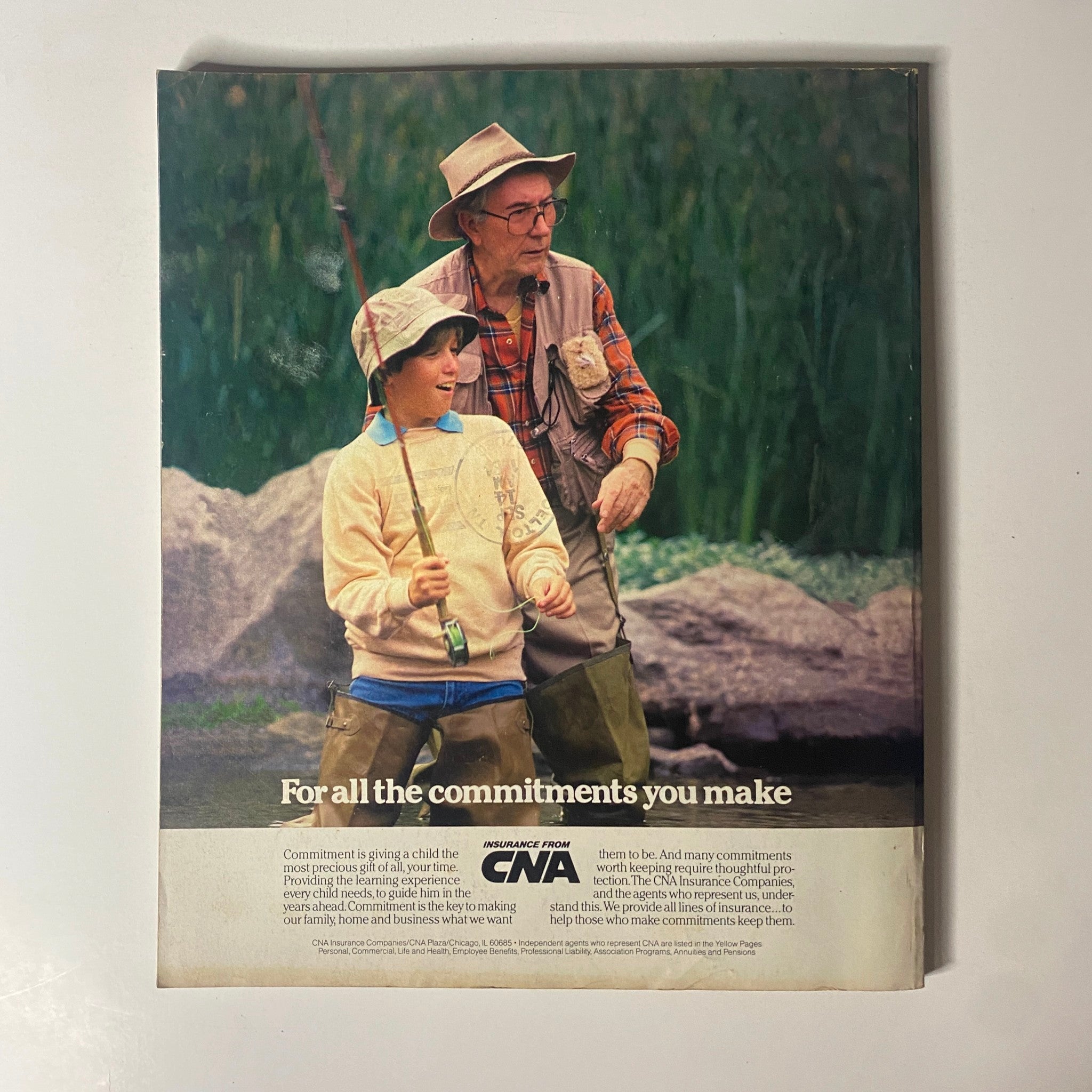 Back cover of Fortune Magazine October 1, 1984, displaying an advertisement from CNA Insurance featuring a grandfather and grandson fishing, highlighting themes of commitment.