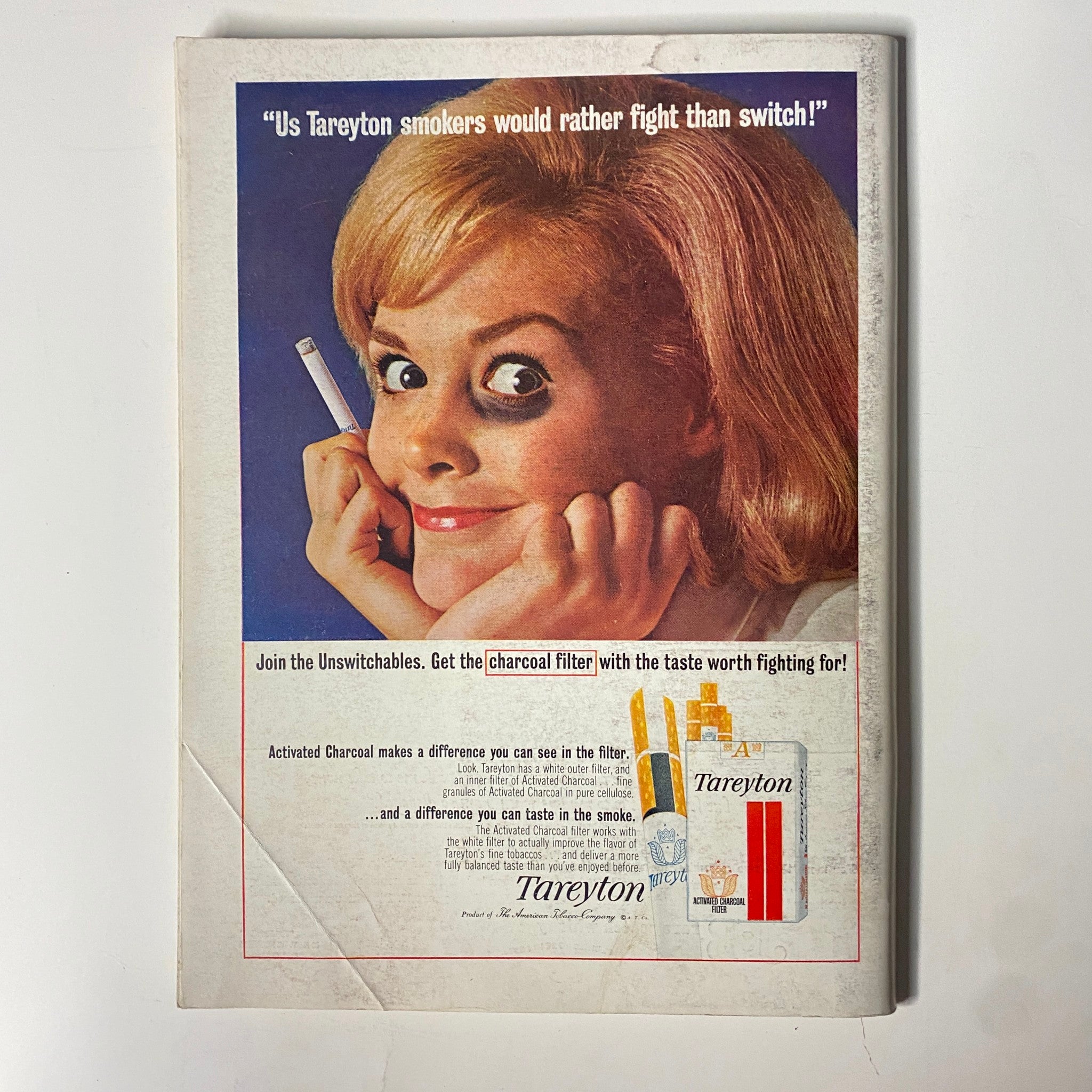 Back cover of Playboy Magazine November 1964 featuring a Tareyton cigarette advertisement. The ad features a woman smiling with a cigarette, promoting the brand's charcoal filter for a taste worth fighting for.