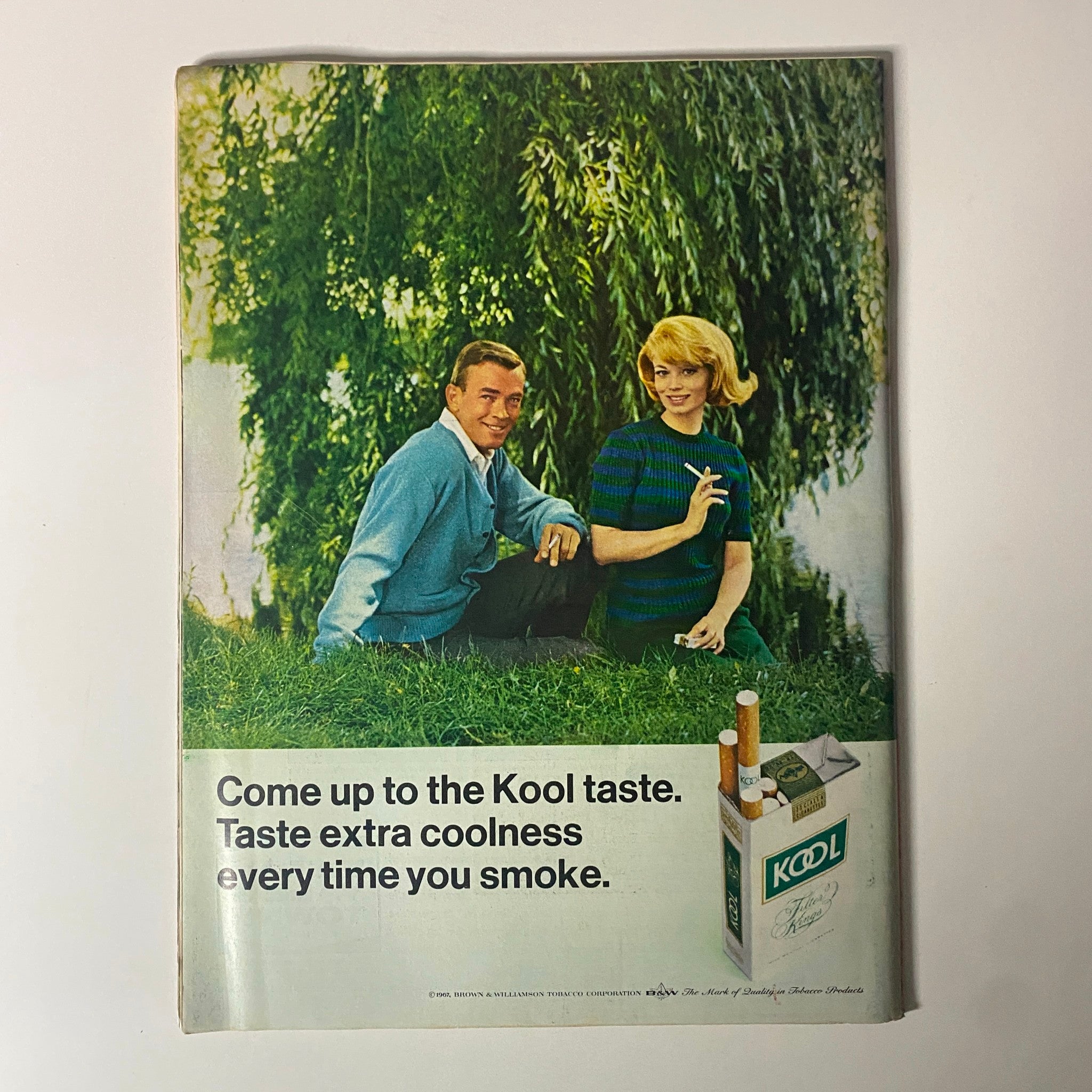 Vintage advertisement featuring two models promoting Kool cigarettes, with the tagline 'Come up to the Kool taste. Taste extra coolness every time you smoke.' This image is related to the January 6, 1967, issue of Time Magazine, Vol 89 No. 1, titled 'Twenty-Five and Under.