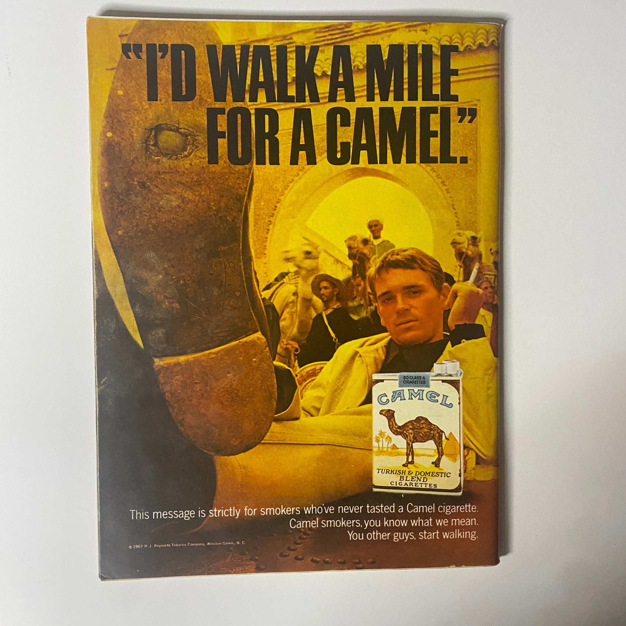 Cover advertisement from the September 22, 1967, Time Magazine Vol 90 No. 12, featuring a Camel cigarette ad with the slogan 'I’d walk a mile for a camel.' A visually striking image emphasizing a unique marketing message for smokers.