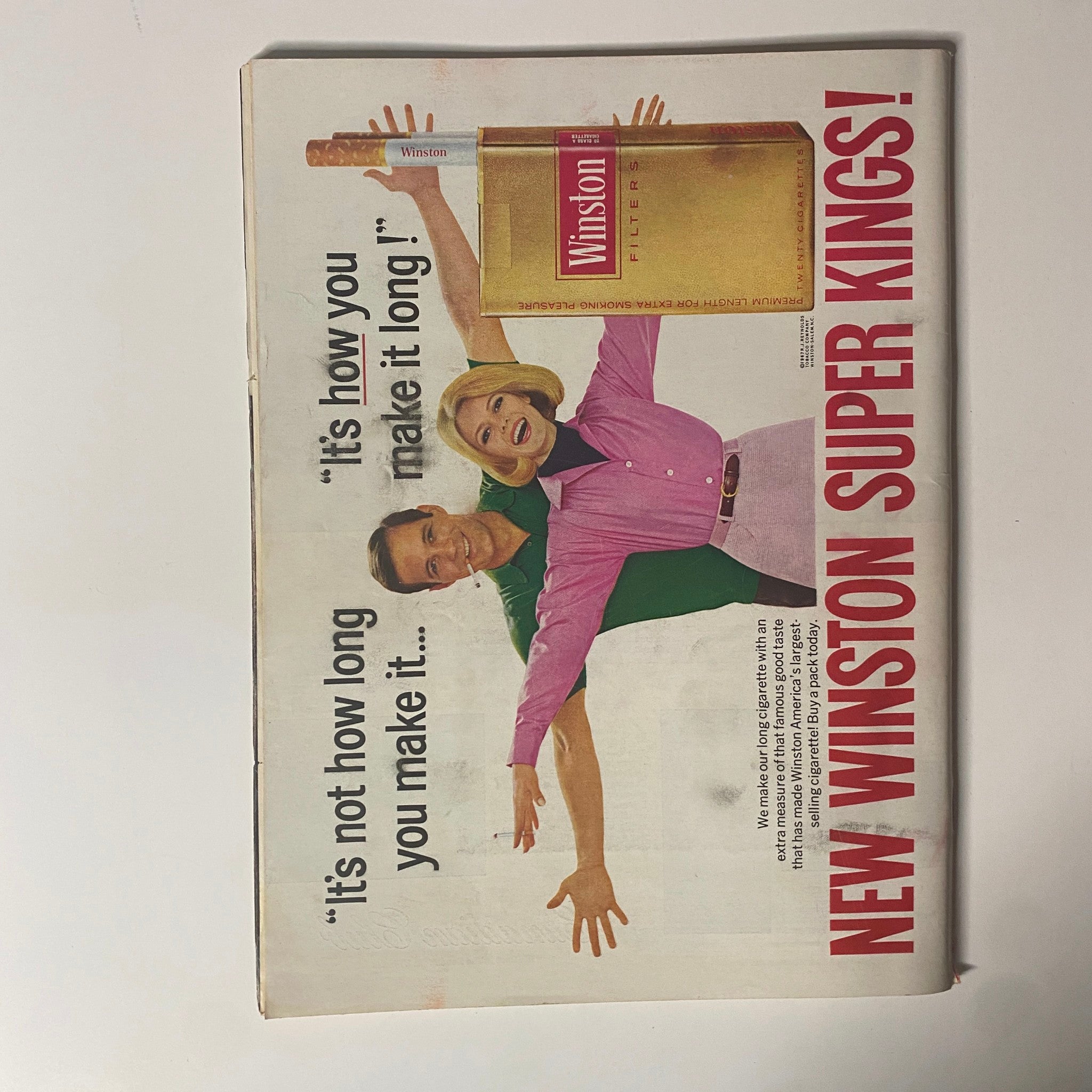 Advertisment page from Time Magazine, featuring Winston Super Kings cigarettes with a slogan and imagery of a man and woman.