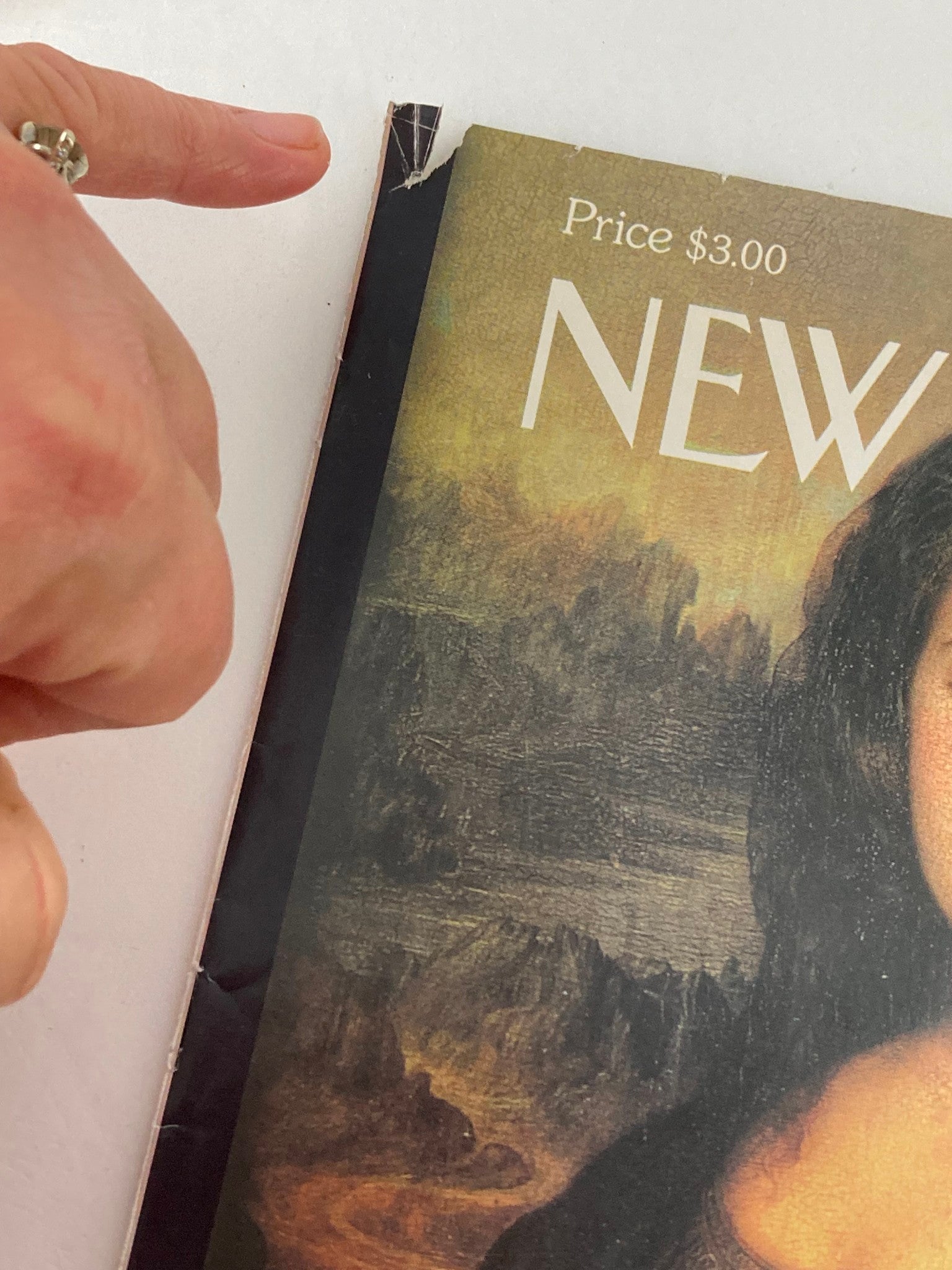 Close-up of the top corner of The New Yorker February 8, 1999 cover, showing wear and tear, highlighting its vintage condition, featuring Monica Lewinsky illustrated by Dean Rohrer.